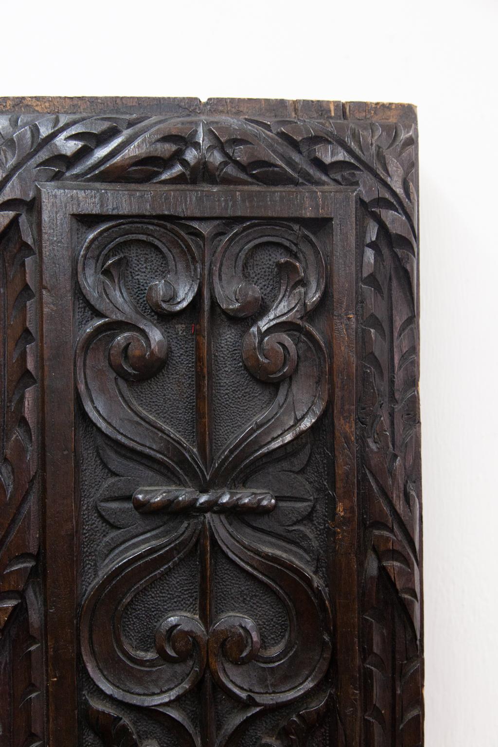 Pair of carved oak panels, will lend an architectural accent to an area. They are carved with linen fold motifs on the lower section. Each has high relief arabesques with stipled background carved in the top portion. They have turned quarter columns