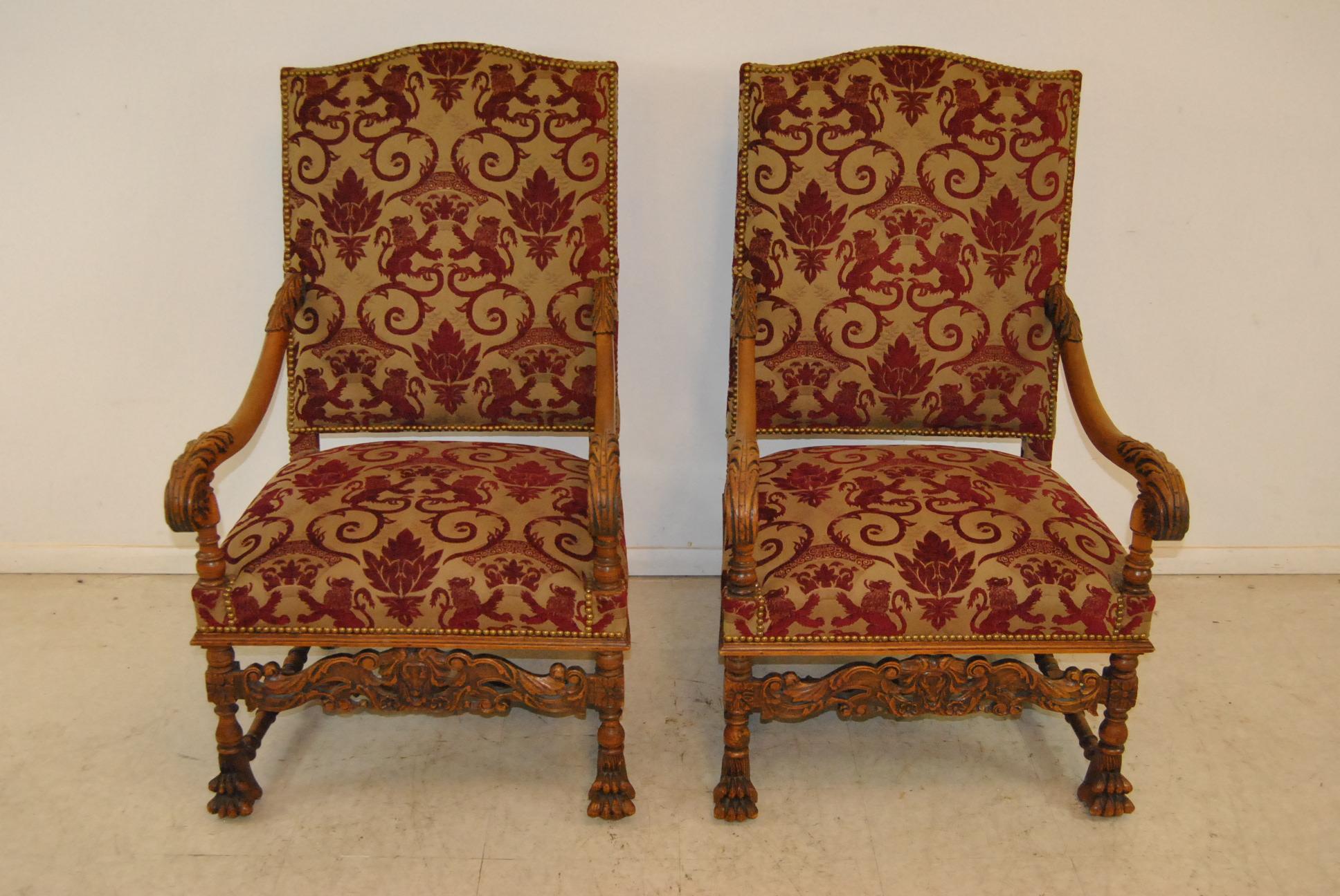A beautiful pair of antique French style Renaissance armchairs. This pair of chairs offers a stately presentation. They are done in a nice oak with scrolling carved arms that have deep relief carving. Very nice and well executed. The chair frames