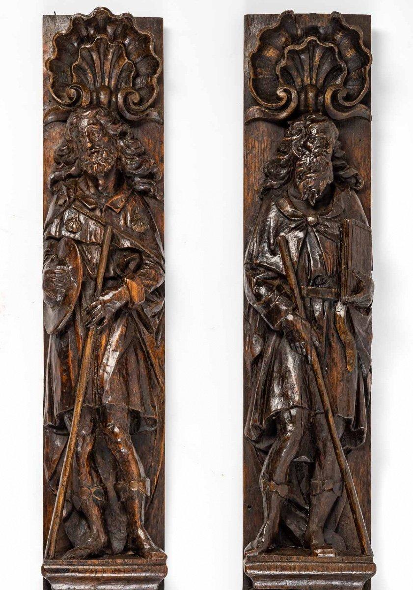 Sublime pair of carved oak panels, featuring two distinct representations of one of the first apostles of Christ, Saint Jacques le Majeur.

The first panel reveals a pilgrim apostle, under an enormous sculpted scallop shell, like a halo, a