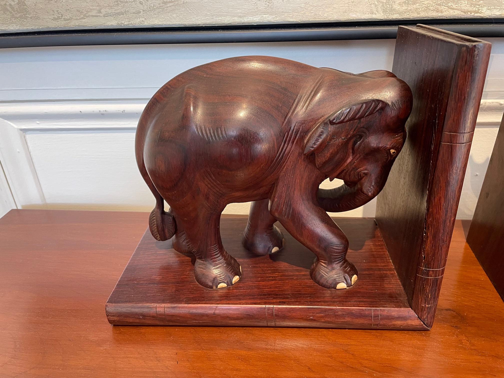 A pair of handsome, hand-carved elephant bookends.  The elephants themselves are carved from one piece of wood.  They stand on a rosewood 