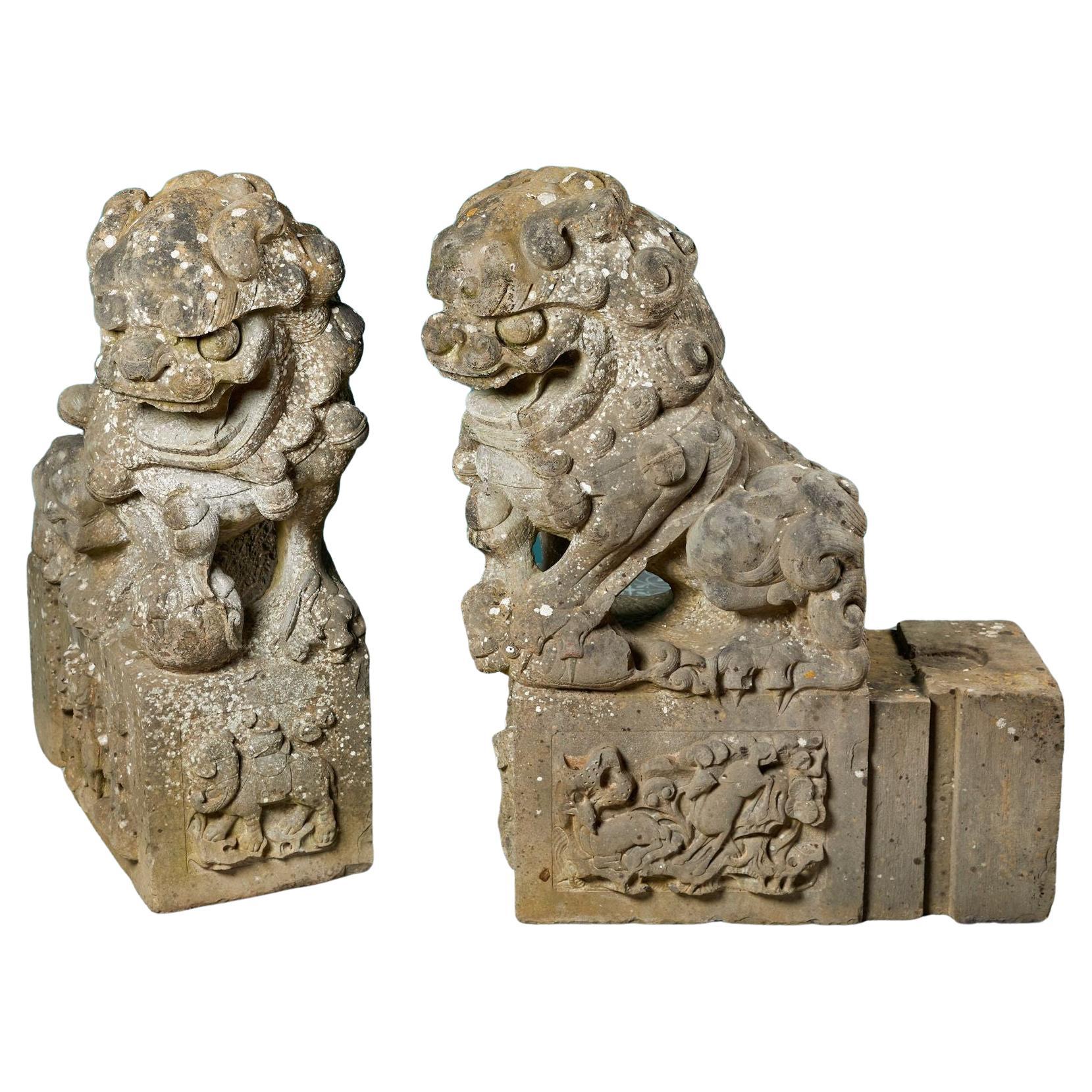 Paar geschnitzte chinesische Wächterlöwenstatuen aus Stein