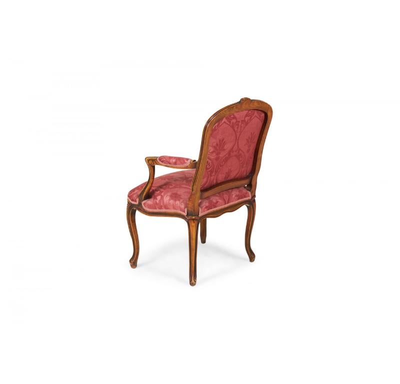 Francese Coppia di poltrone imbottite in legno di noce intagliato e damasco rosa e rosso in vendita