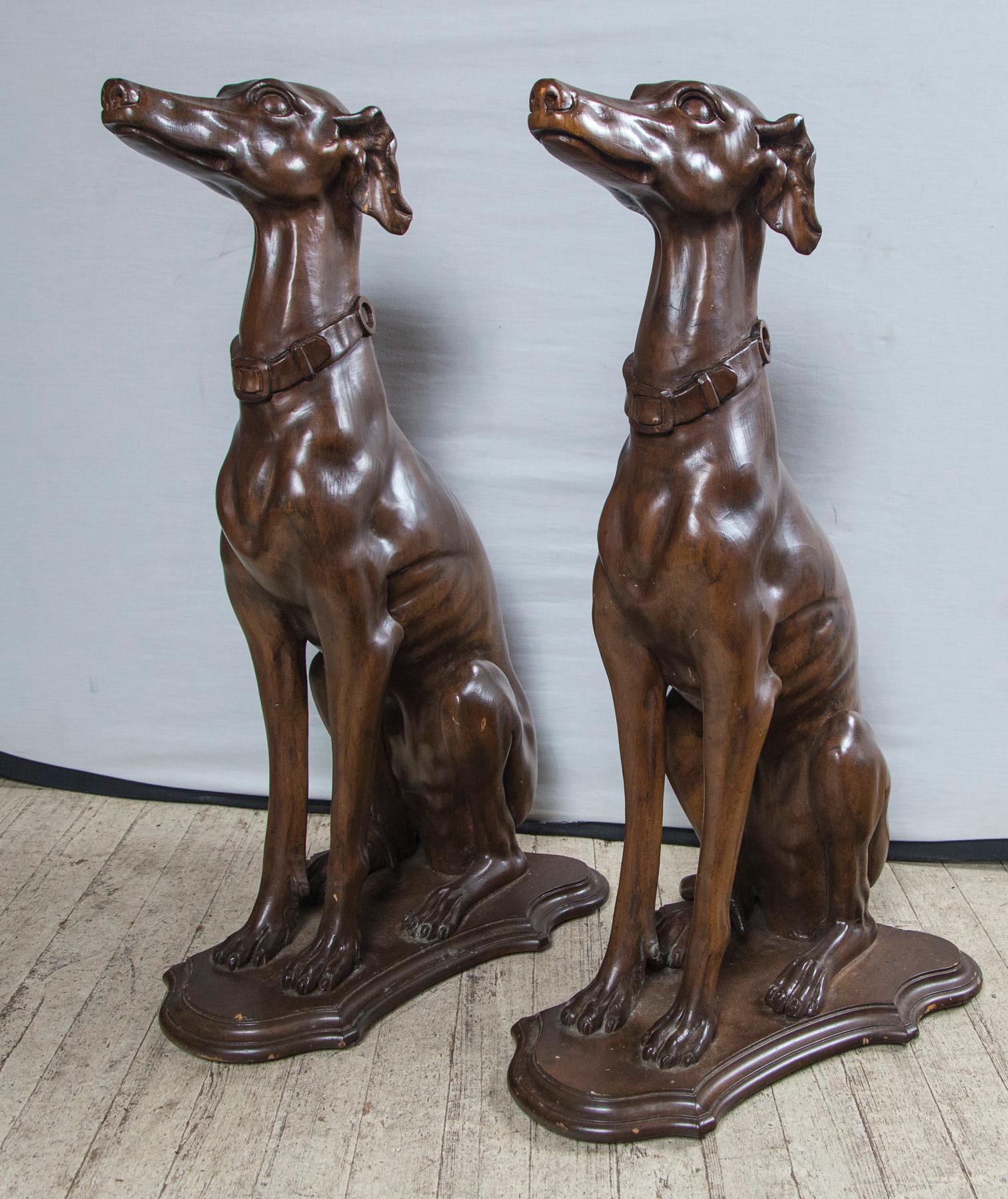 The dogs, which we believe to be whippets or Italian greyhounds, are sitting on their haunches. Each has a buckled dog collar around the neck. They are attached to cartouche shaped bases. The depth and width are the measurements for the cartouche
