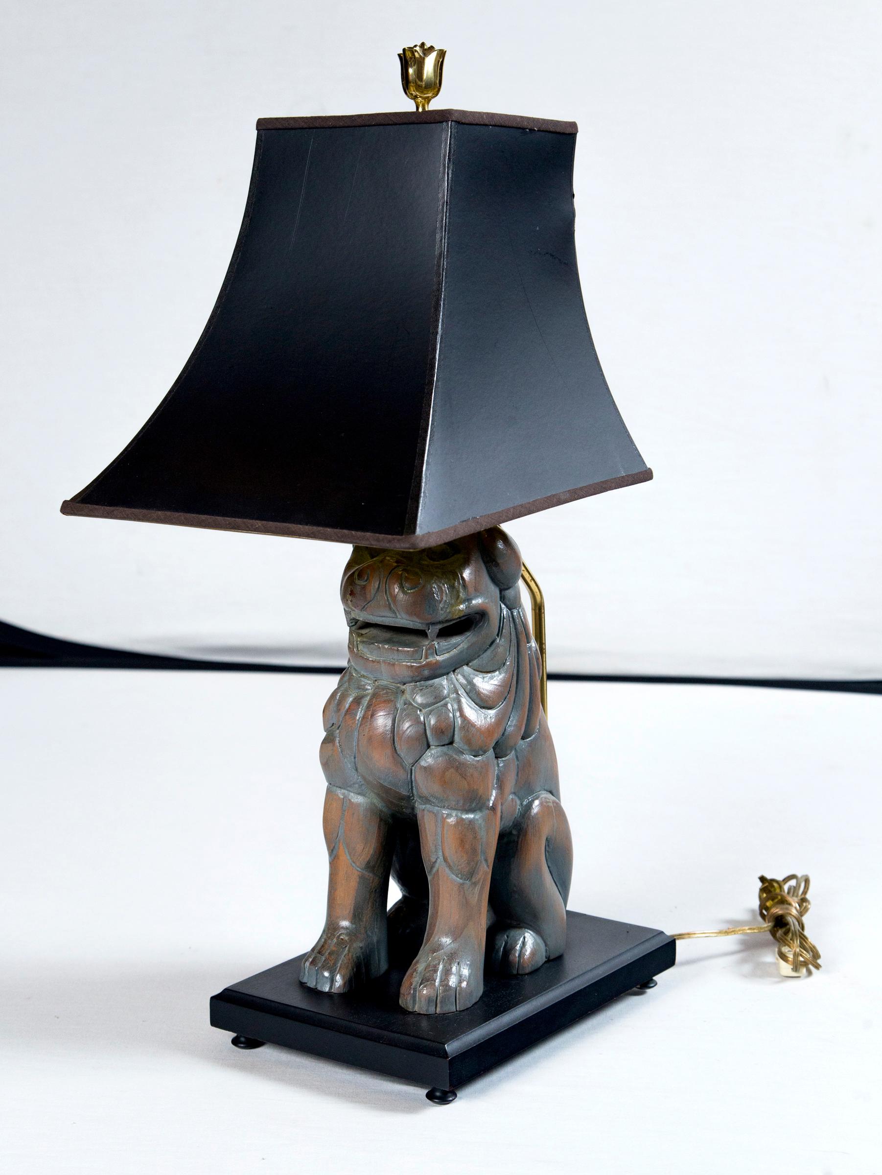 Ein Paar geschnitzte Holzlampen Foo Dog von Sarreid aus Spanien. Geformte Lampenschirme aus schwarzem Papier mit goldener Innenseite. Die Hunde sitzen auf schwarz lackierten Holzsockeln. Die Hunde allein sind 5 Zoll breit, 7,5 Zoll tief und 12 Zoll