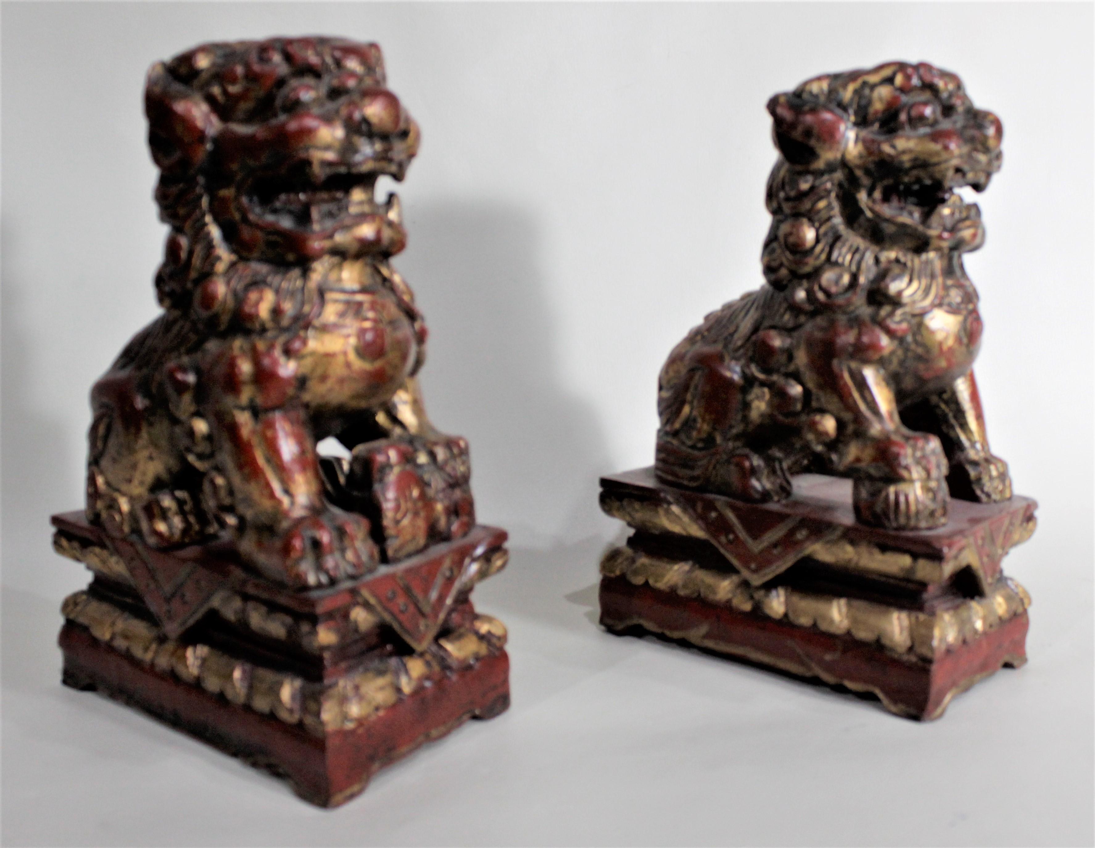 This pair of intricately hand carved and hand painted Foo dogs are believed to have made in the mid-20th century in the Imperial style. The dogs are composed of a softwood which have been hand carved in considerable detail and painted in a deep red