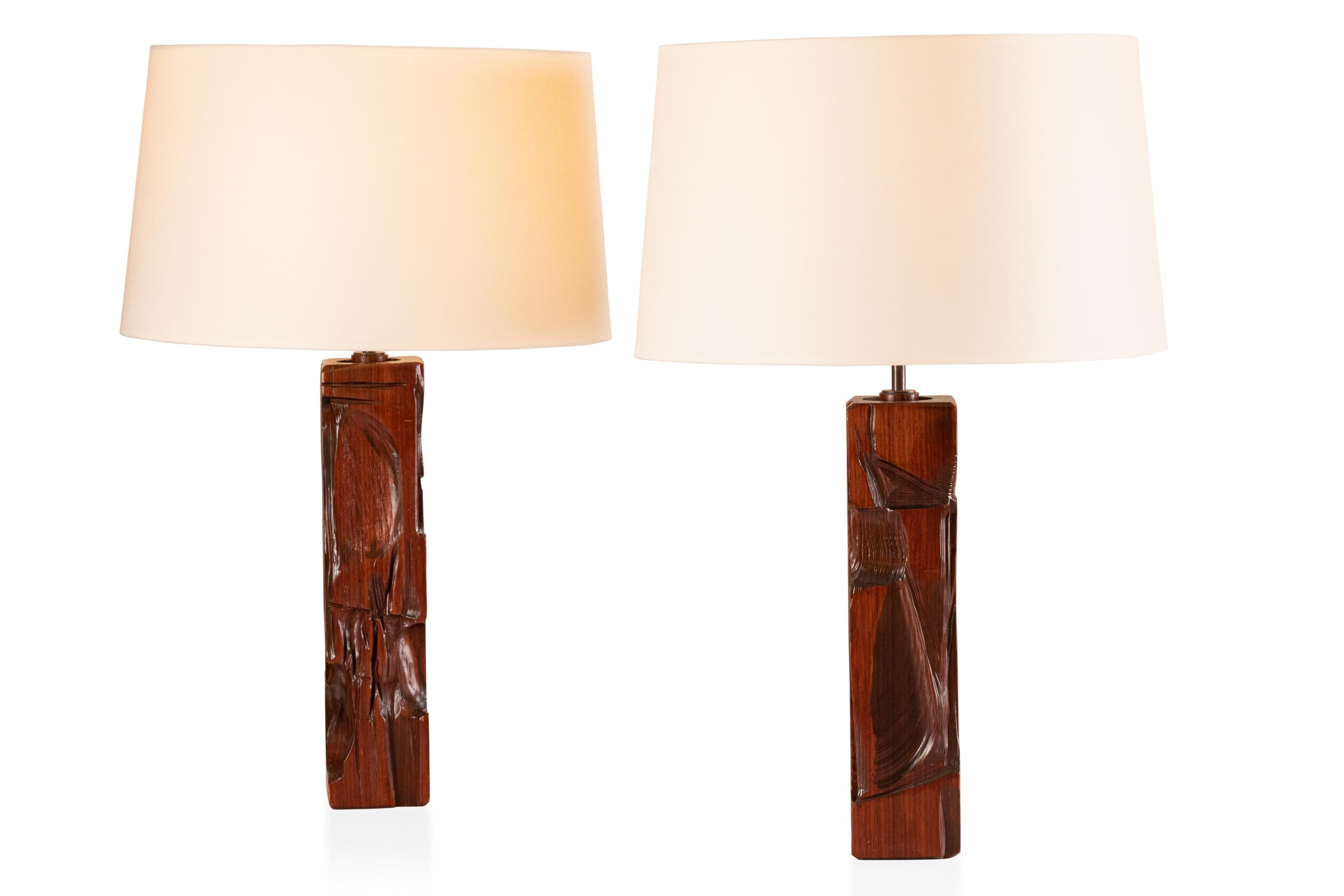Pair of carved wood table lamps.
Varnished walnut.
Design Gianni Pinna.
signed.
Italy, 1970

Measures: Height total : 70 cm - 27.5 in.
Diameter shade : 45 cm - 17.7 in.
Height foot 1 : 39,5 cm - 15.5 in.
Height food 2 : 41 cm - 16.1