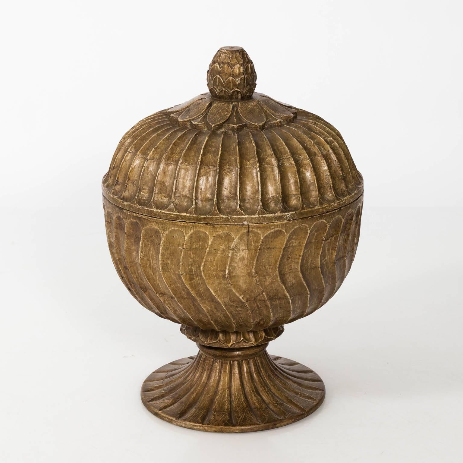 Contemporary Moroccan inspired carved wood urns with carved finial lids.
      