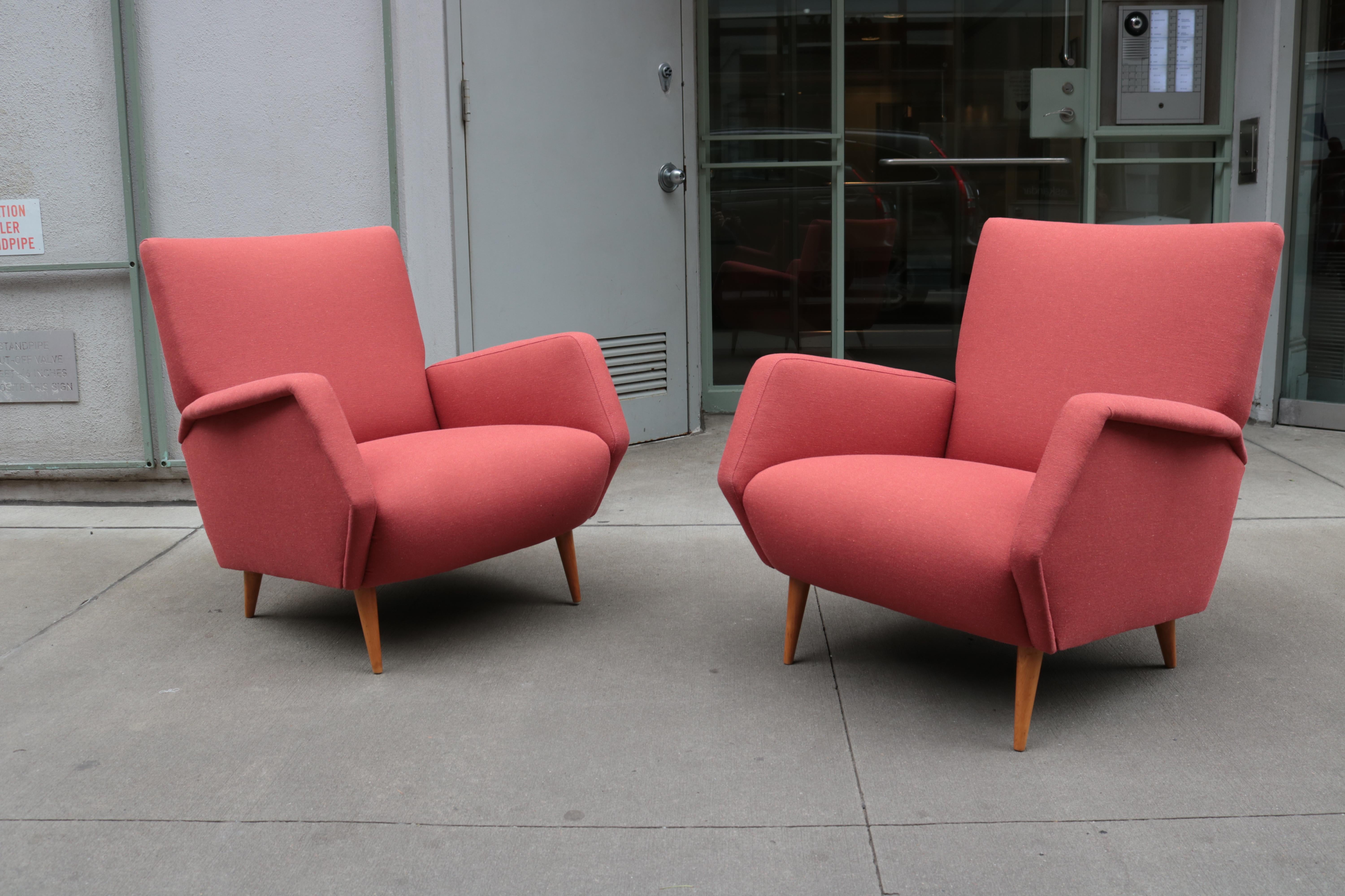 A pair of Cassina armchairs designed by Gio Ponti. 
Model # 803. 
Upholstered frame with wood legs.