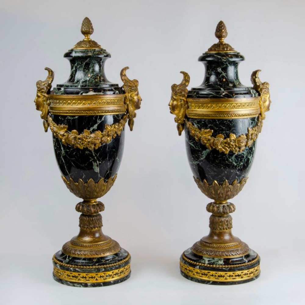 Superbe paire d'urnes en marbre et bronze doré de style Louis XVI du XIXe siècle. Chacune est posée sur une base carrée en marbre avec une garniture en bronze doré et une couronne de laurier en bronze doré au-dessus. Le corps repose sur un socle en
