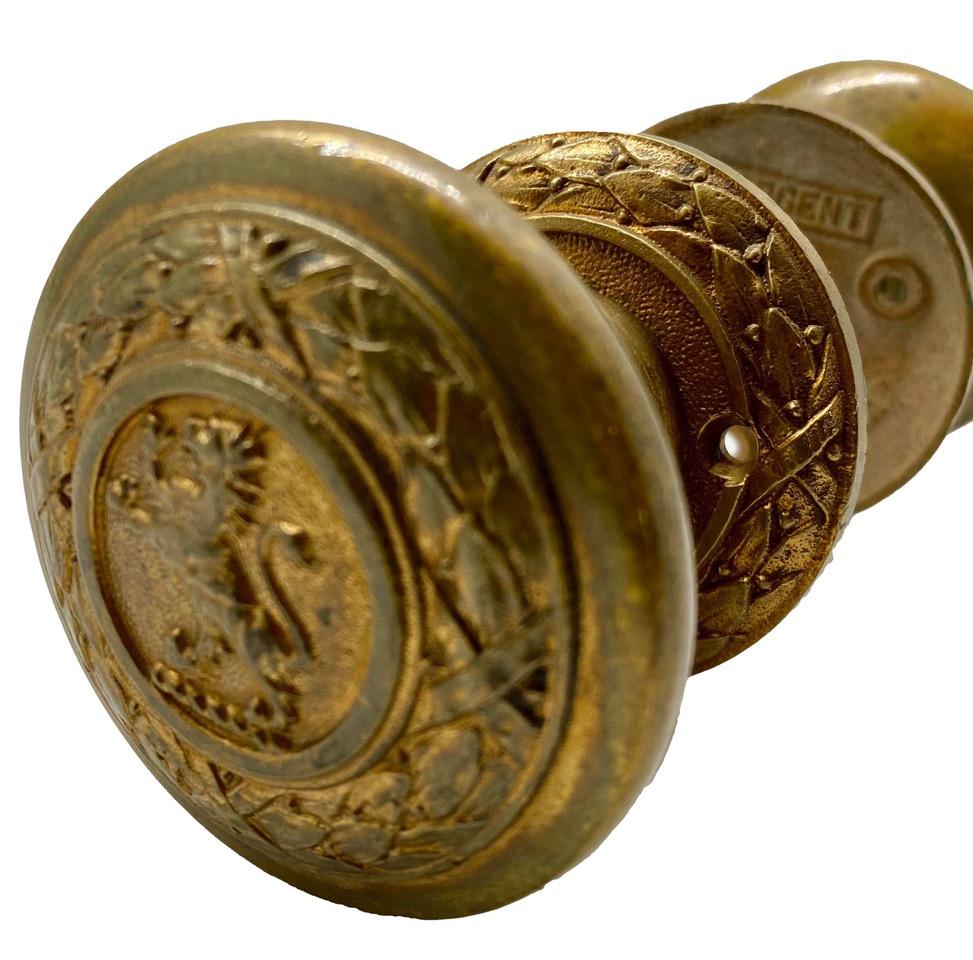 Pair of Sargent and Company 1920s cast brass standing lion door knob set originally from the Palmer House Hotel in Chicago. Set includes two knobs, two rosettes, and a spindle.