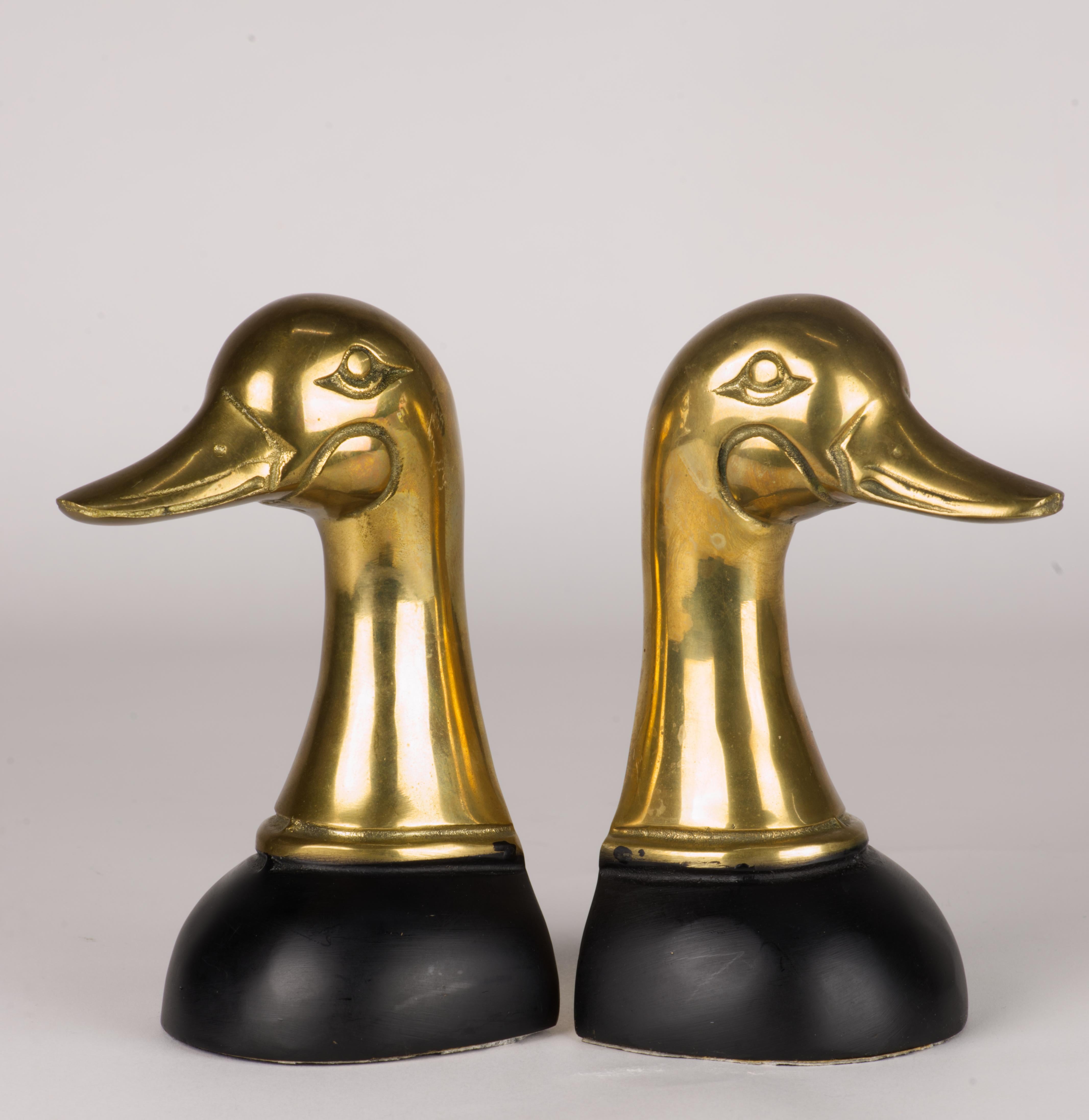  Vintage pair of Mallard duck bookends is made of polished cast brass with detailed eyes, cheeks and beaks. The wide bases curve gently down, providing extra stability to the heavy, substantial pieces; the bases are done in matte black finish on top