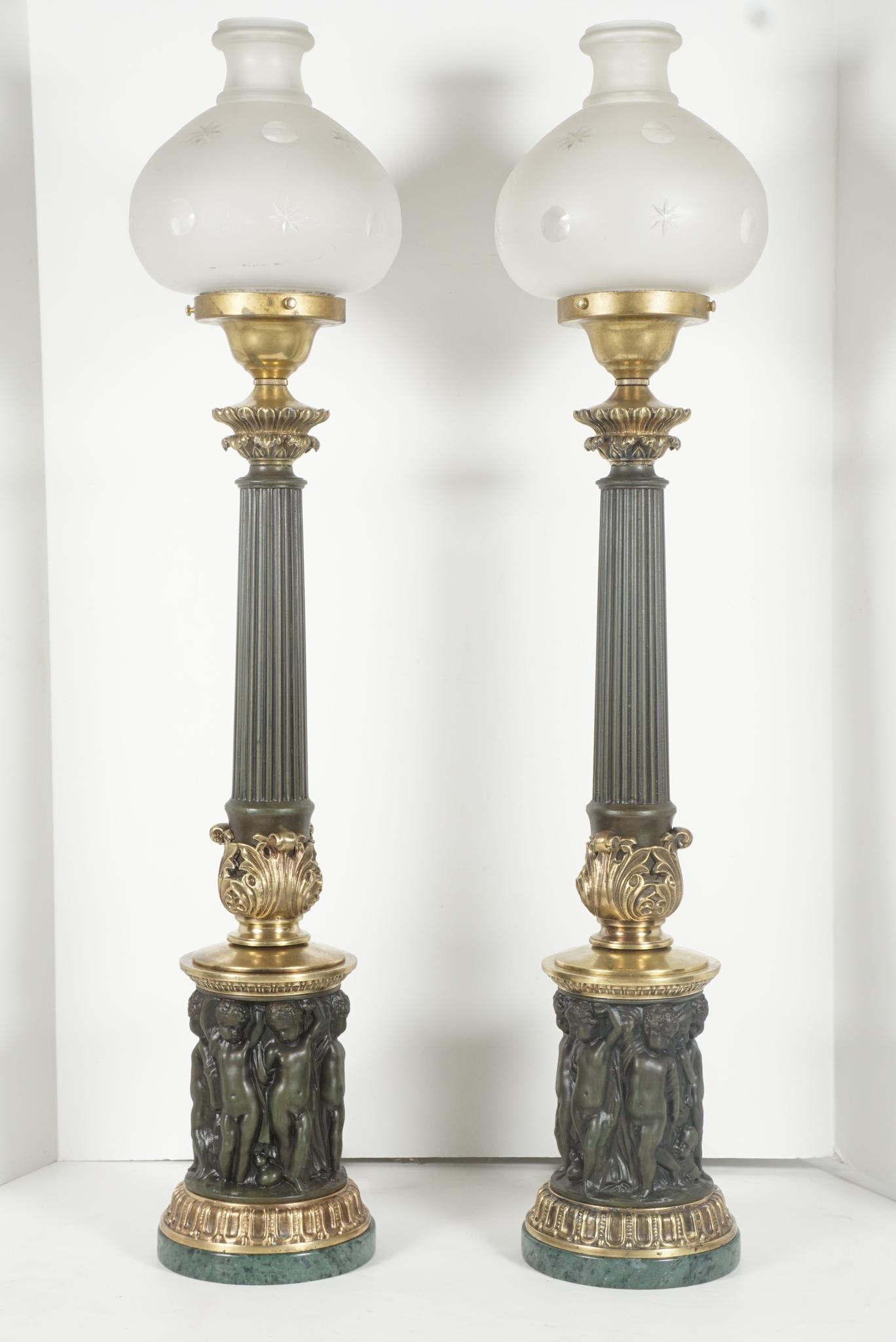 This pair of very dramatic tall cast & tole neoclassical sinumbra style lamps with frosted etched glass shades appear to be antique from the 1820s however are made circa 1930. Cast in heavy brass and tole painted they are most probably European in