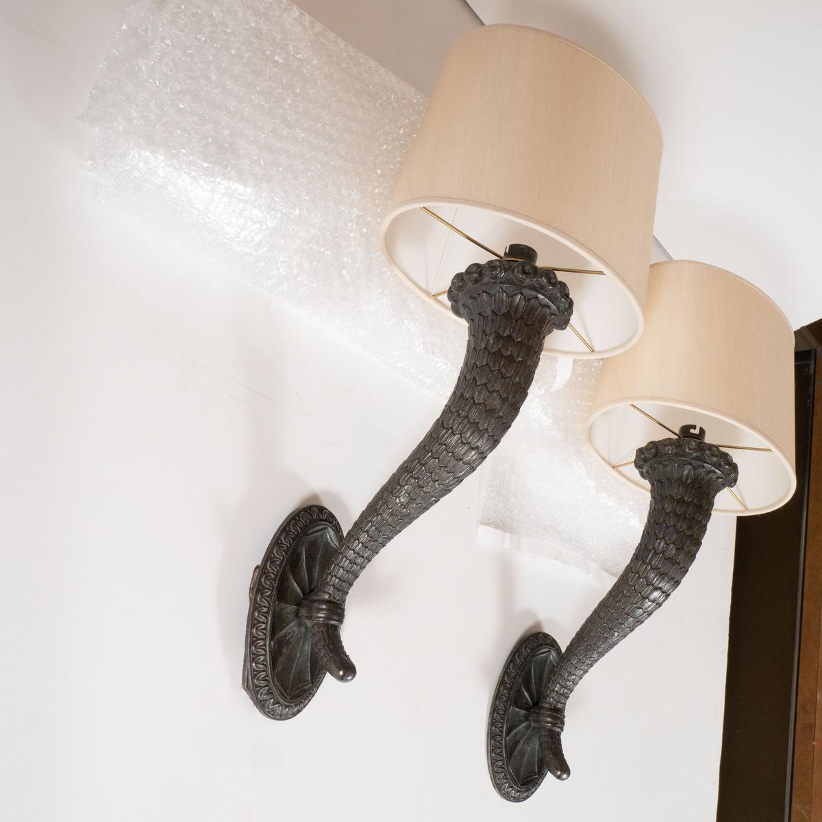 Pair of intricately cast bronze horn form sconces. Measured without shades.
(shades: 8
