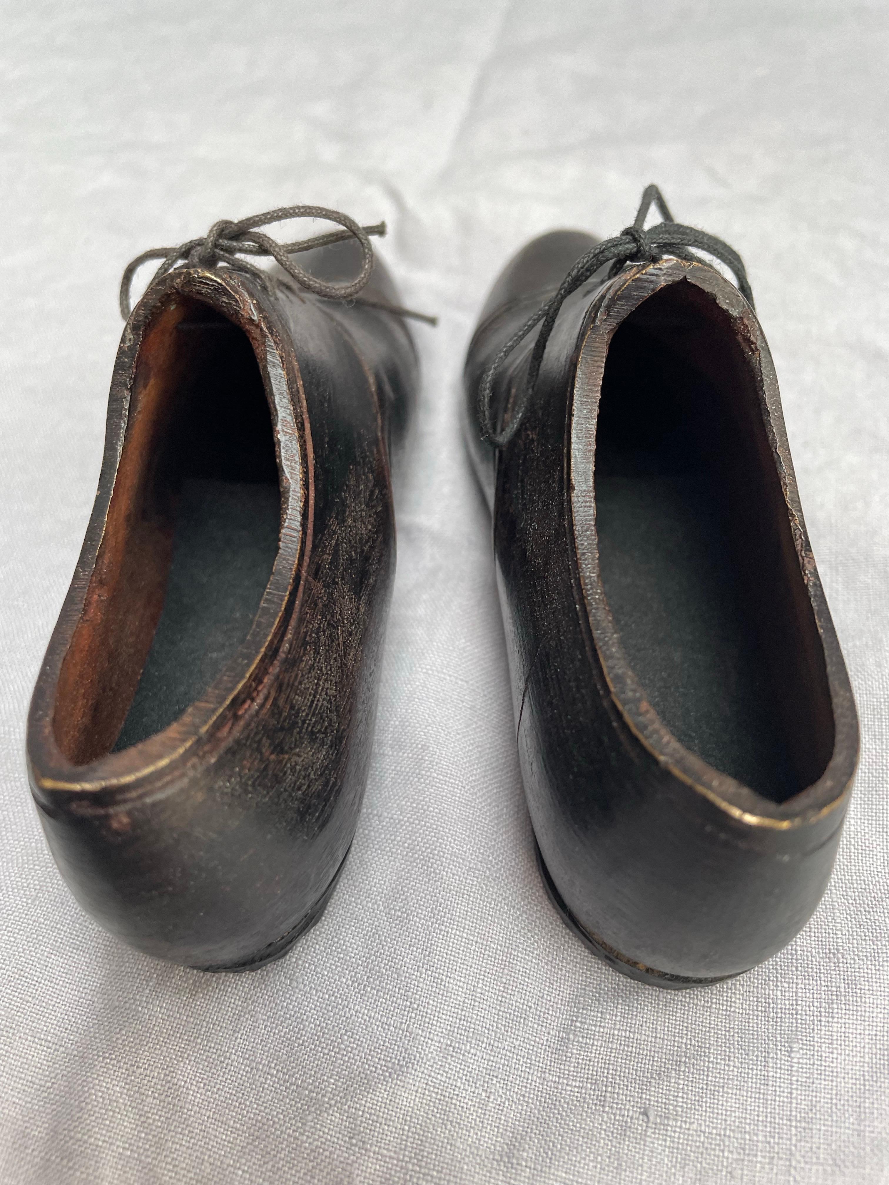 A finely modeled pair of cast bronze men’s lace-up shoes, likely mid-20th century, showcasing remarkable realism and craftsmanship. Each shoe is sculpted in solid bronze with a warm dark patina and intricate detailing that captures the character of