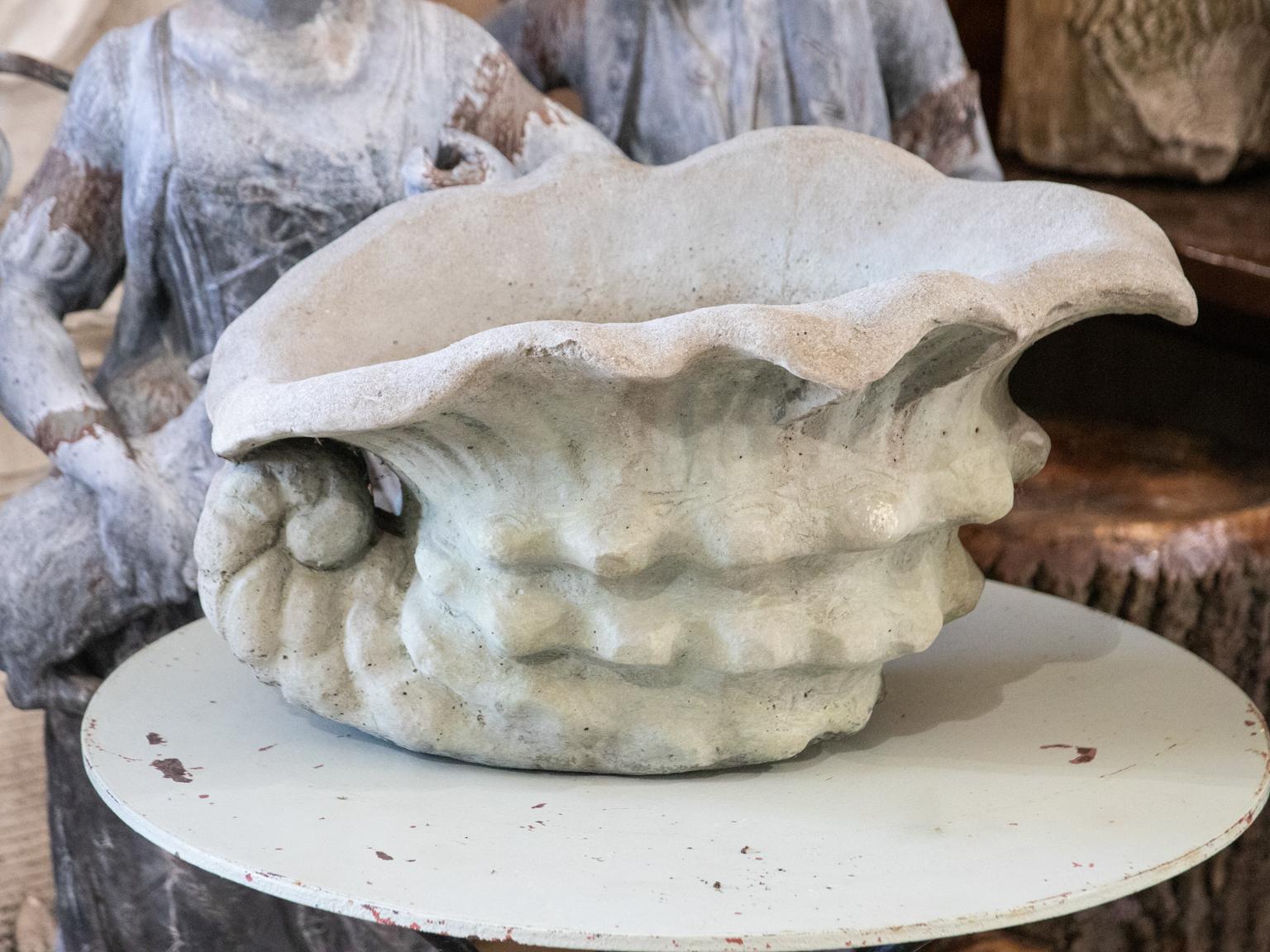 Pair of cast cement Neoclassical style shell shaped planters in a weathered finish. Please note of wear consistent with age including minor chips and finish loss on the exterior and minor discoloration on the interior.