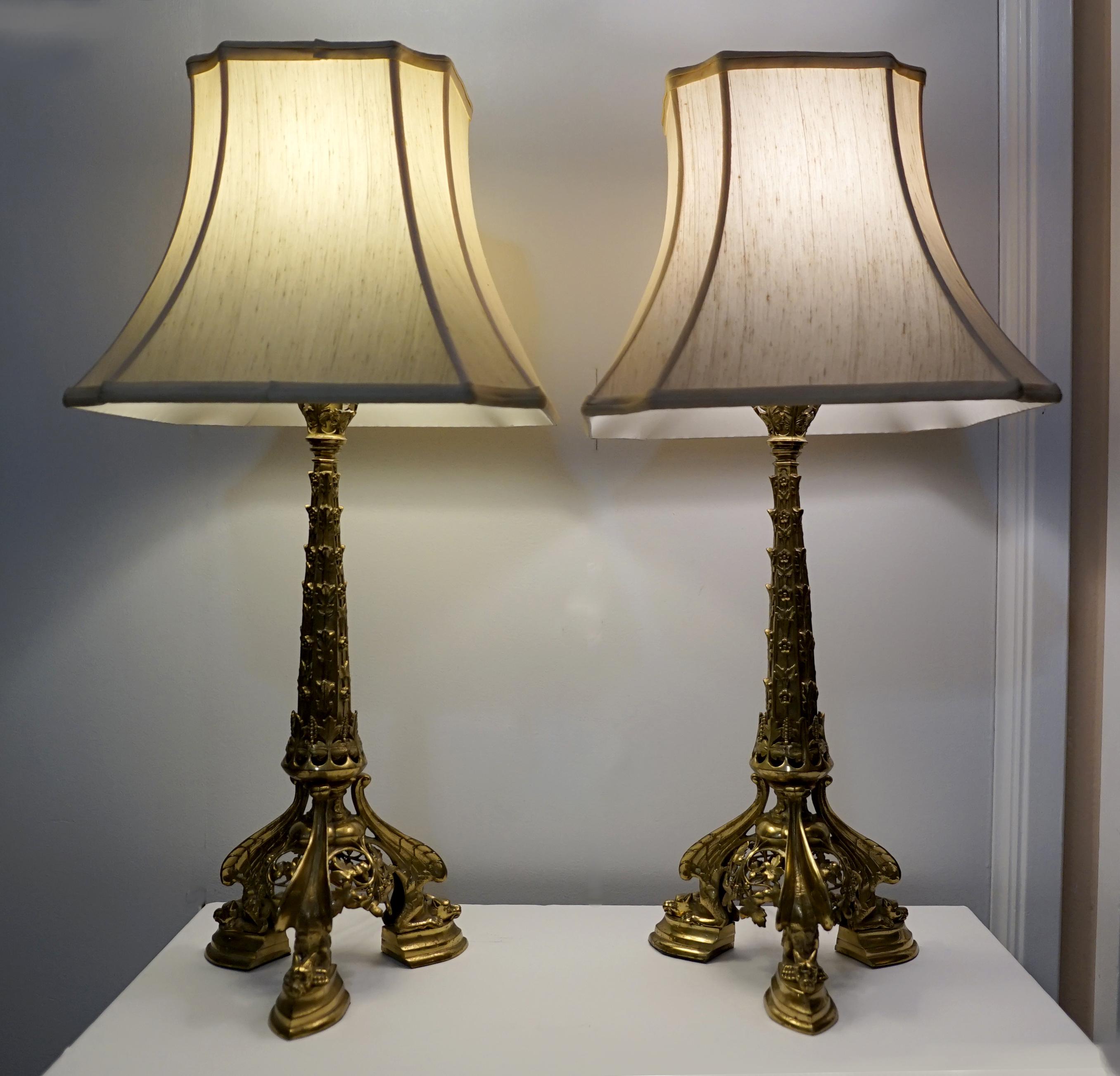 Gold and gargoyles combine to create an elegant lighting opportunity in this pair of lamps made in Canada. The French Rococo influence is apparent in the gilded cast design and the tower silhouette with intricate bronze gilt work. Perhaps most