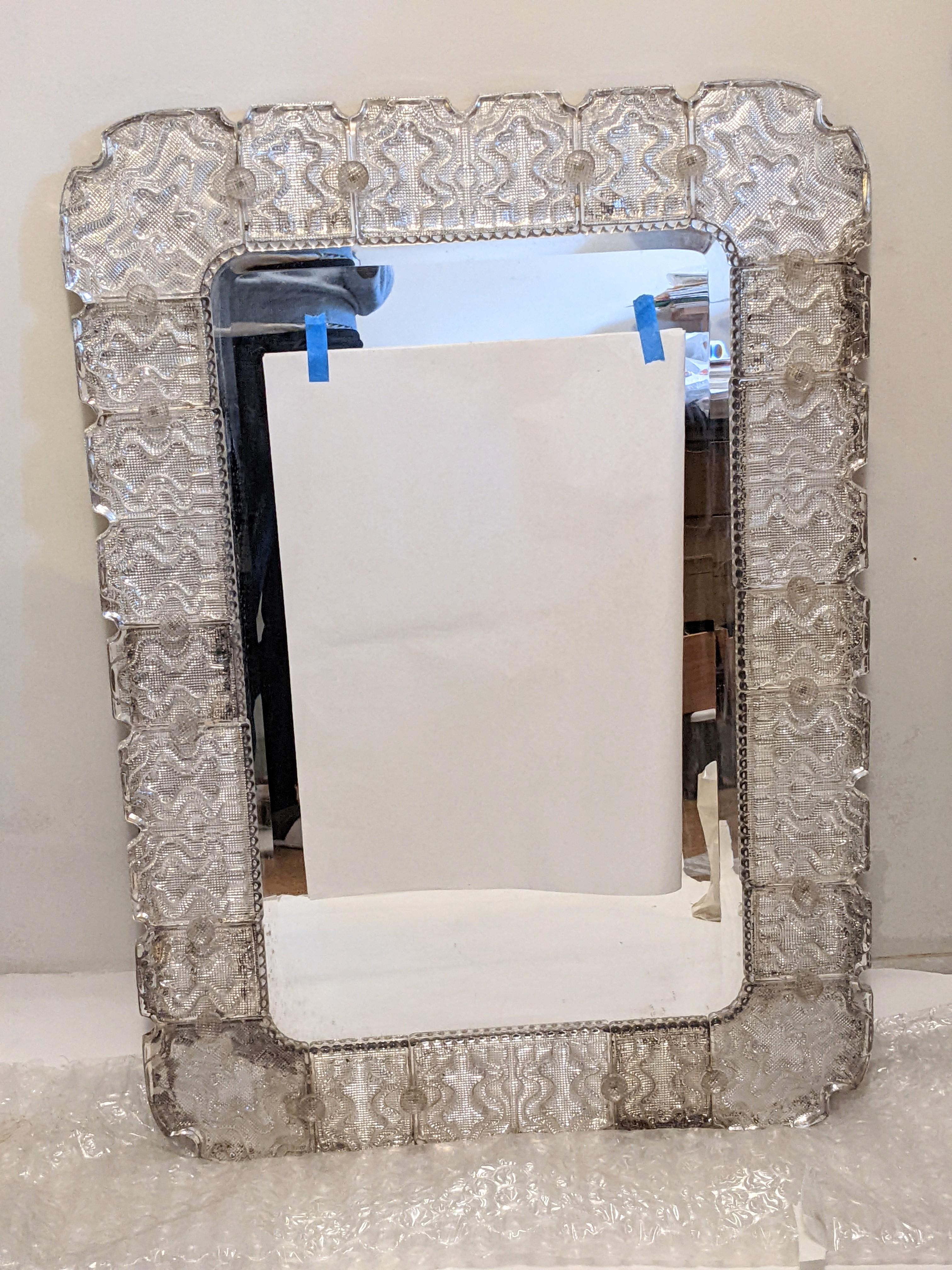 A stunning and elegant pair of Carl Fagerlund cast glass framed wall mirrors made for Orrefors, Sweden, 1950s. Each wall mirror has molded cast glass tiles set onto a heavy wooden frame and secured by cast glass buttons (screws). Each of the tiles