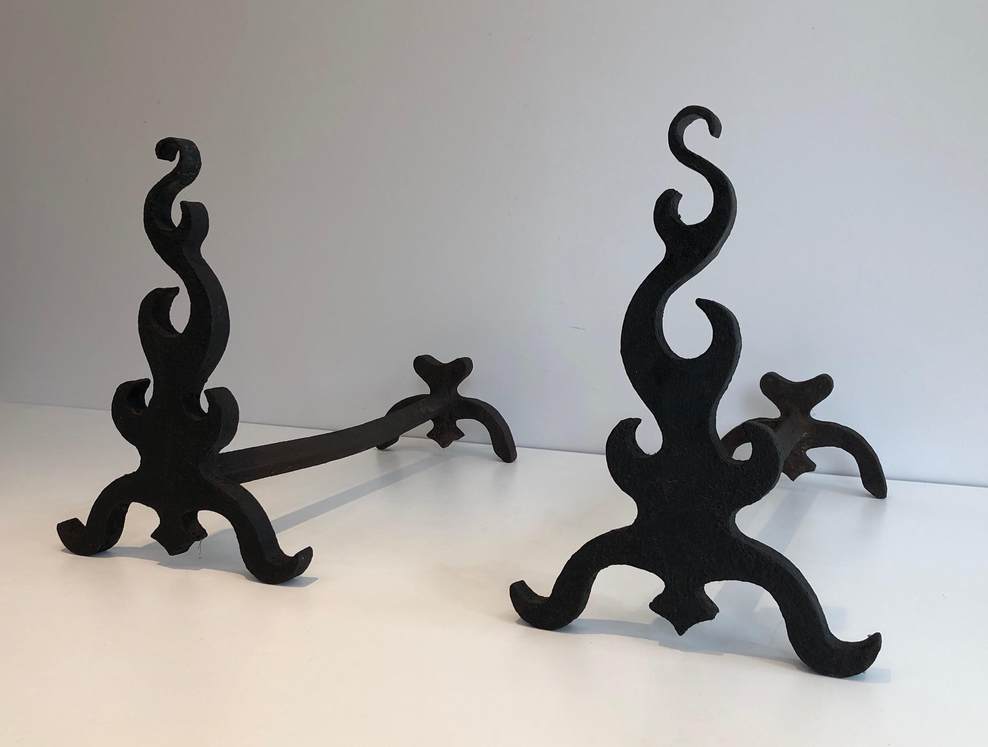This pair of andirons is made of cast iron and wrought iron. This is a French work, circa 1940.