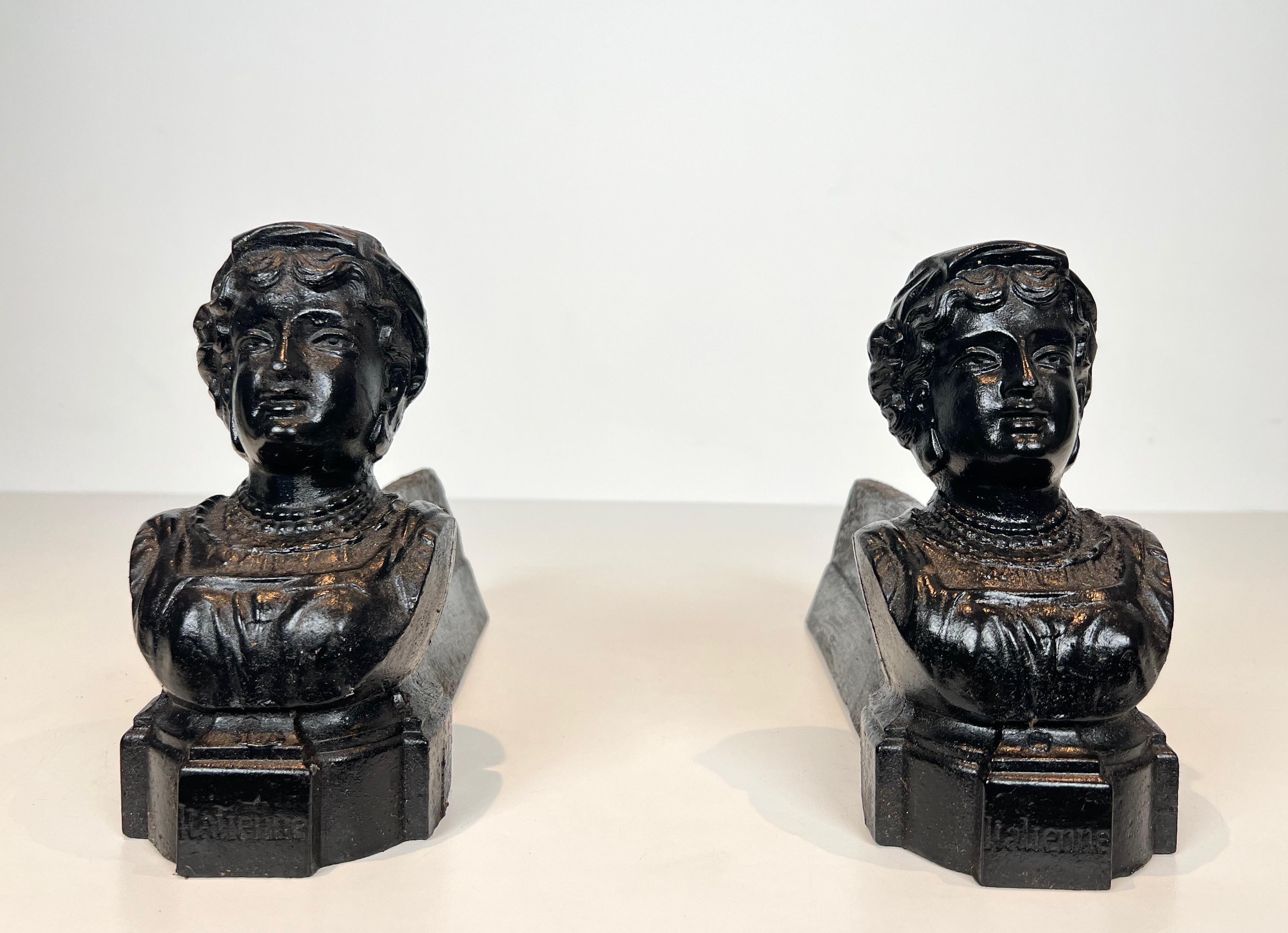 This pair of andirons is made of cast iron. These represent a woman and bearing the word 