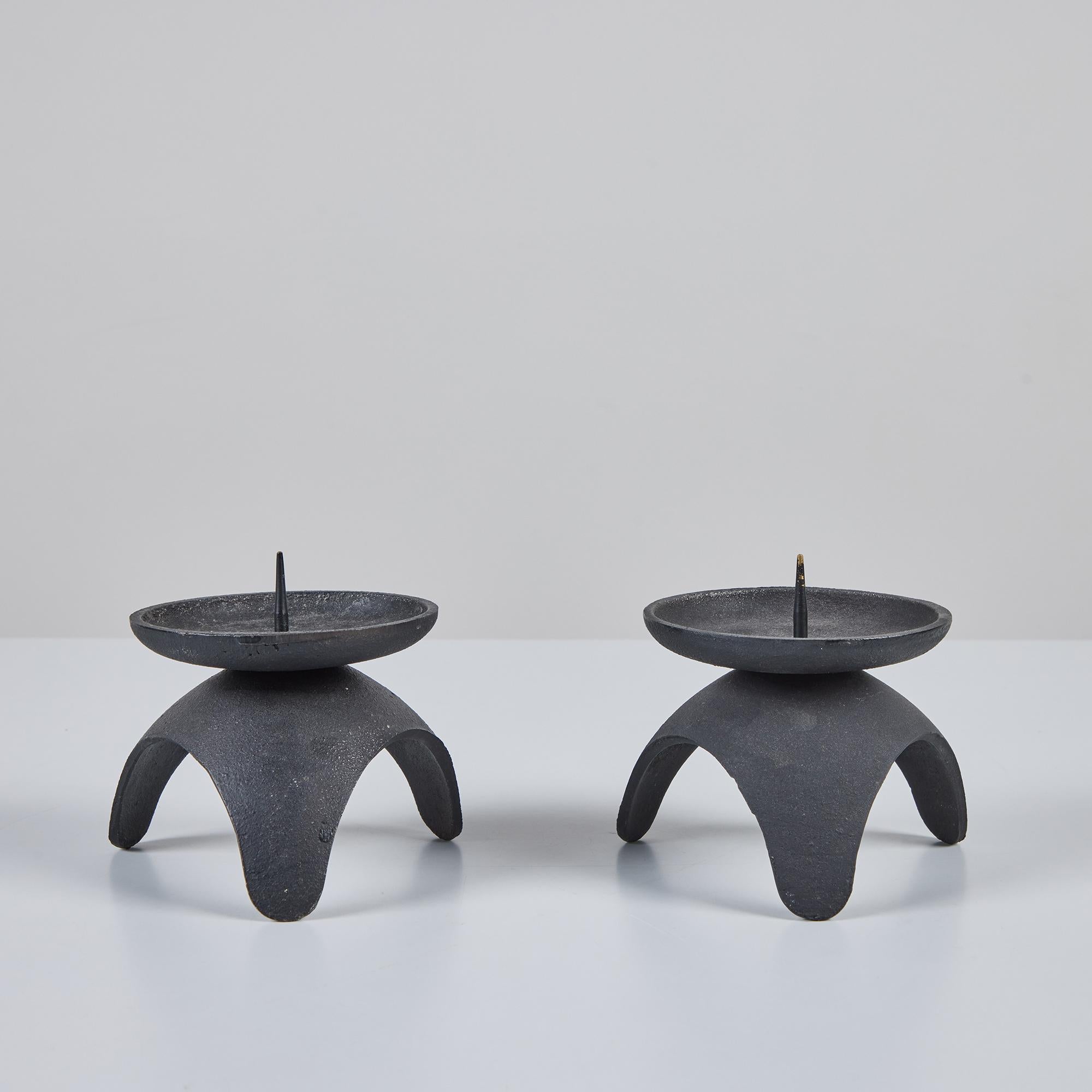Pair of pillar tripod cast iron candle holders. This example was produced in Japan and features a round basin with curved rims and center spikes to hold the candles. 

Dimensions
Each Candle Holder - 4.25