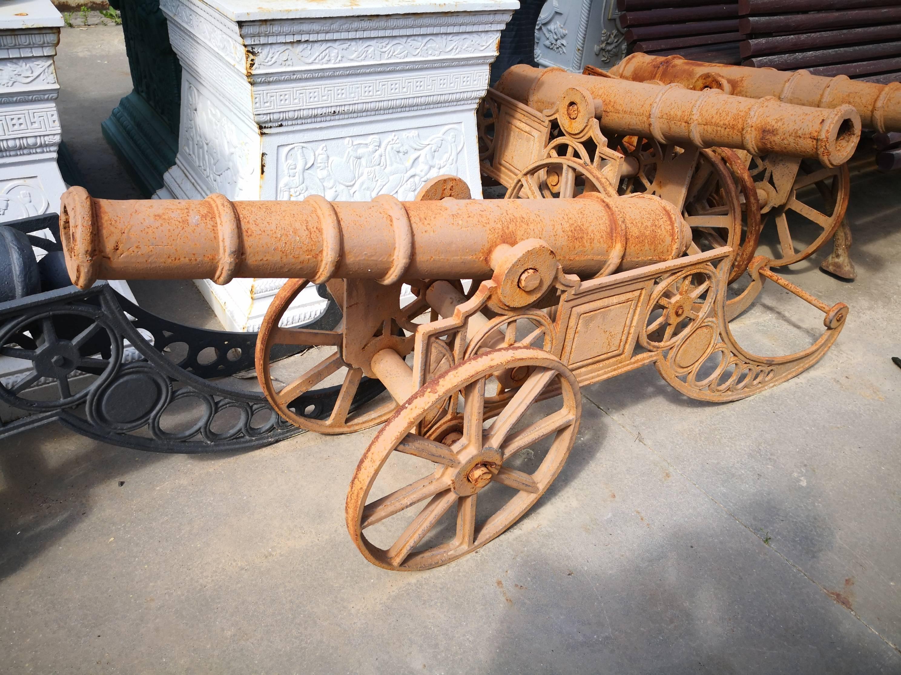 Pair of cast iron cannons on wheels reproductions in a aged brown patina.