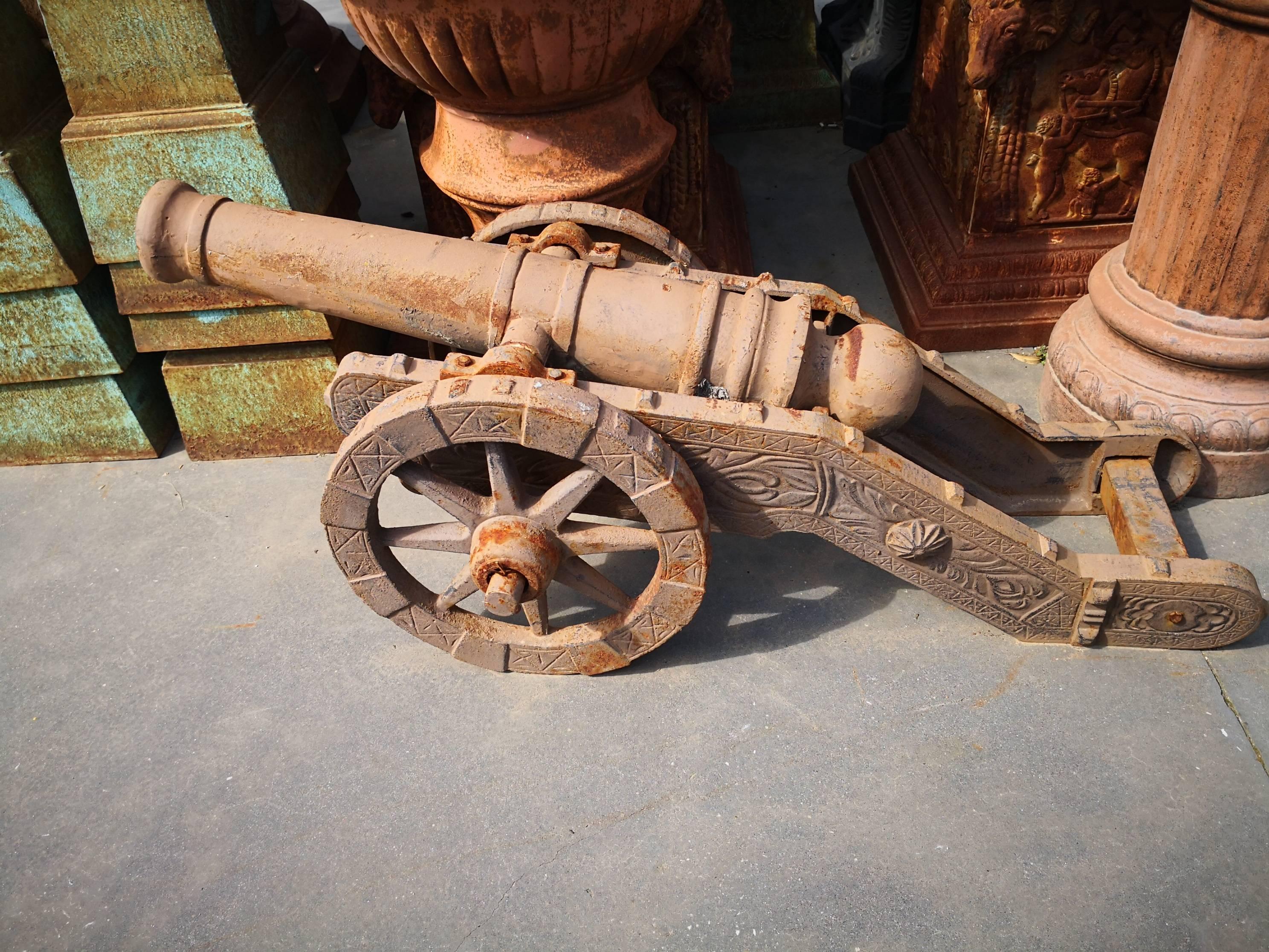 Pair of cast iron cannons on wheels reproductions in a aged brown patina.