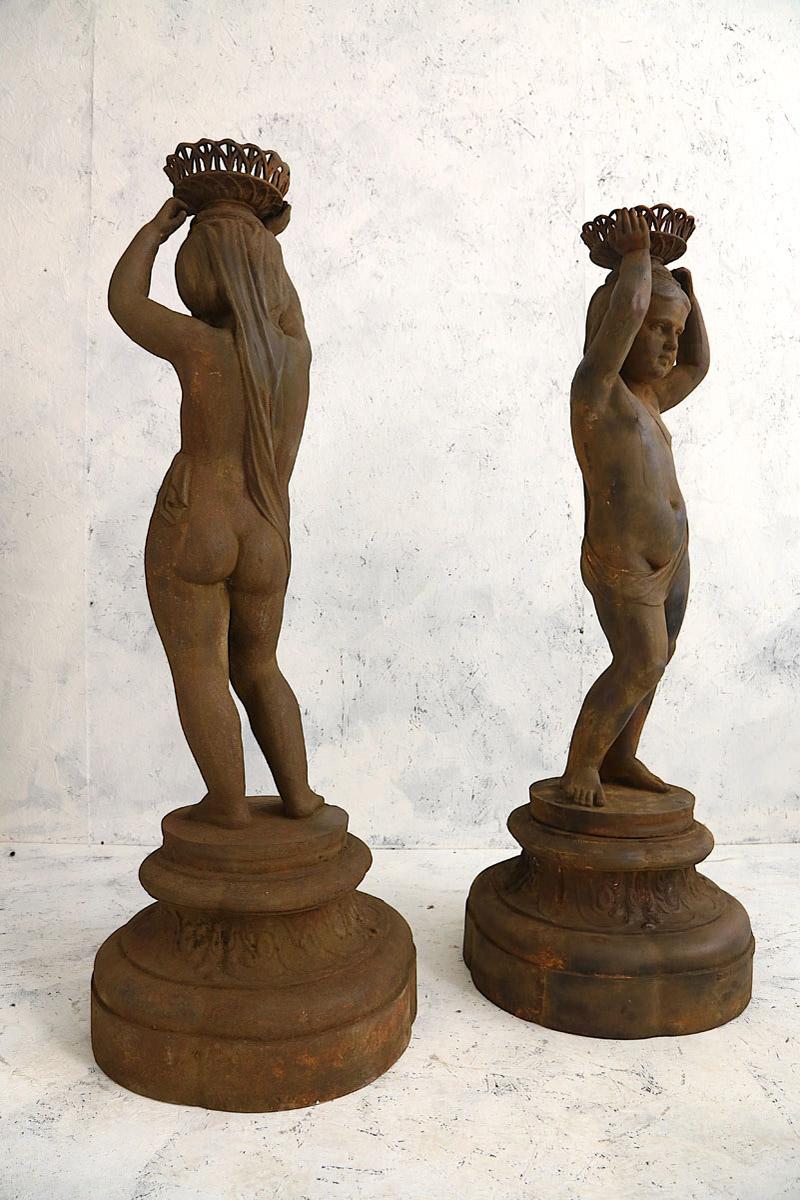 Pair of cast iron figures of girls with baskets attributed to J.J. Ducel Maitre de Forges Paris mounted on a Stockholm Foundry stamped base. These Cast Iron figures of girls work well both externally in the garden or has internal statues 