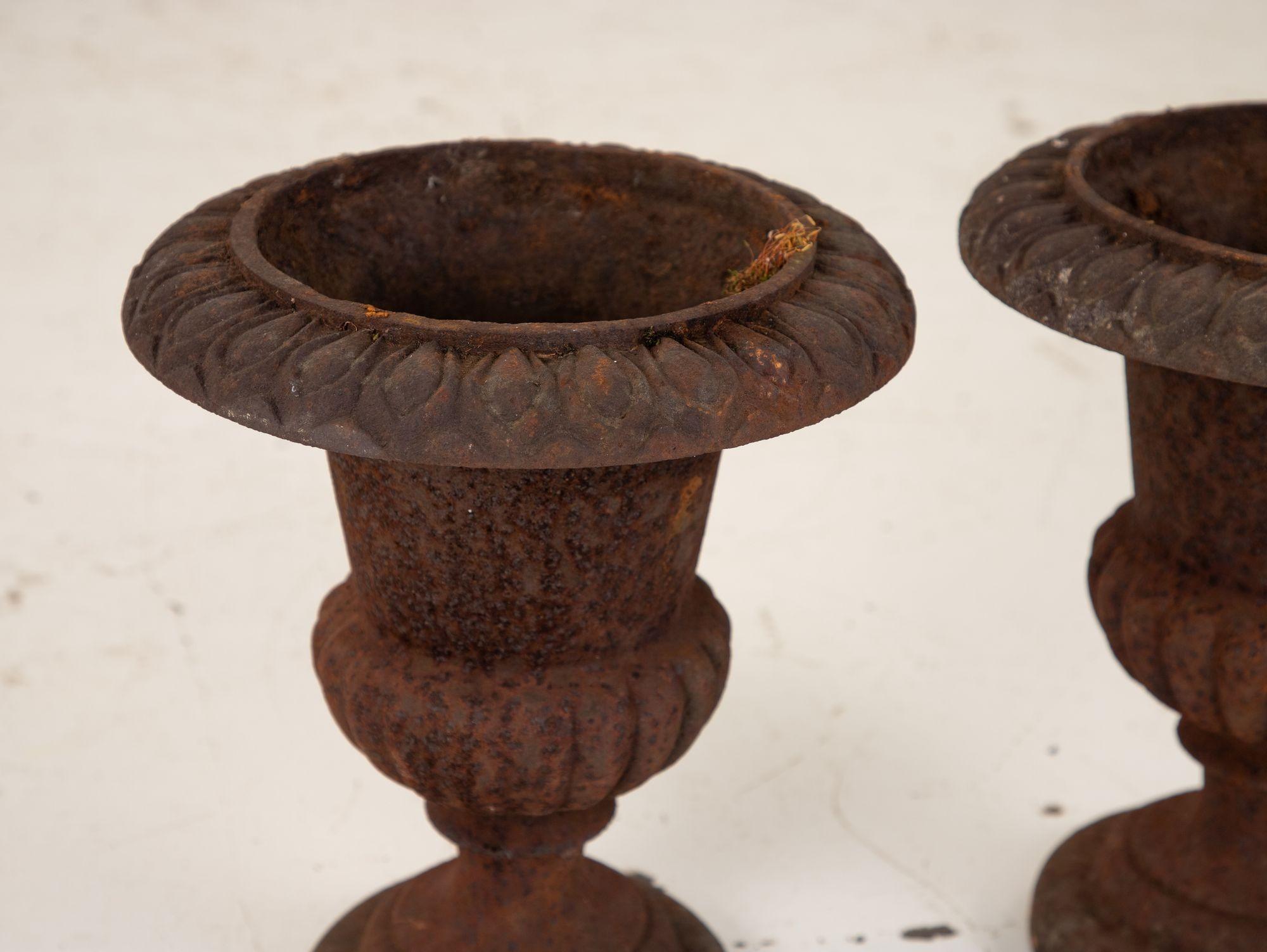 These cast iron urns are a beautiful example of French late 19th-century design. They have a timeless quality that makes them a perfect addition to any garden or outdoor space. The urns are made of solid cast iron, which gives them a substantial