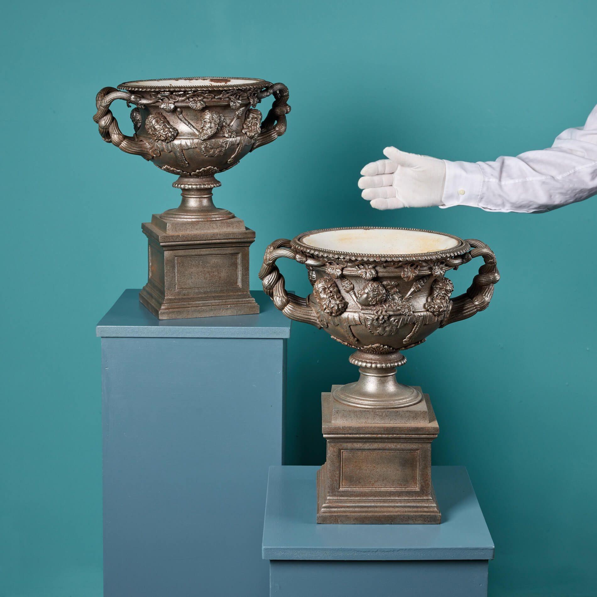 Ein sehr fein gegossenes Paar gusseiserner Modelle der berühmten Warwick-Vase um 1870. Während das Original der Warwick Vase eine kolossale Höhe von 6 Fuß hat, sind diese Repliken nur 40 cm hoch und verleihen einem Interieur, das auf einer Konsole,