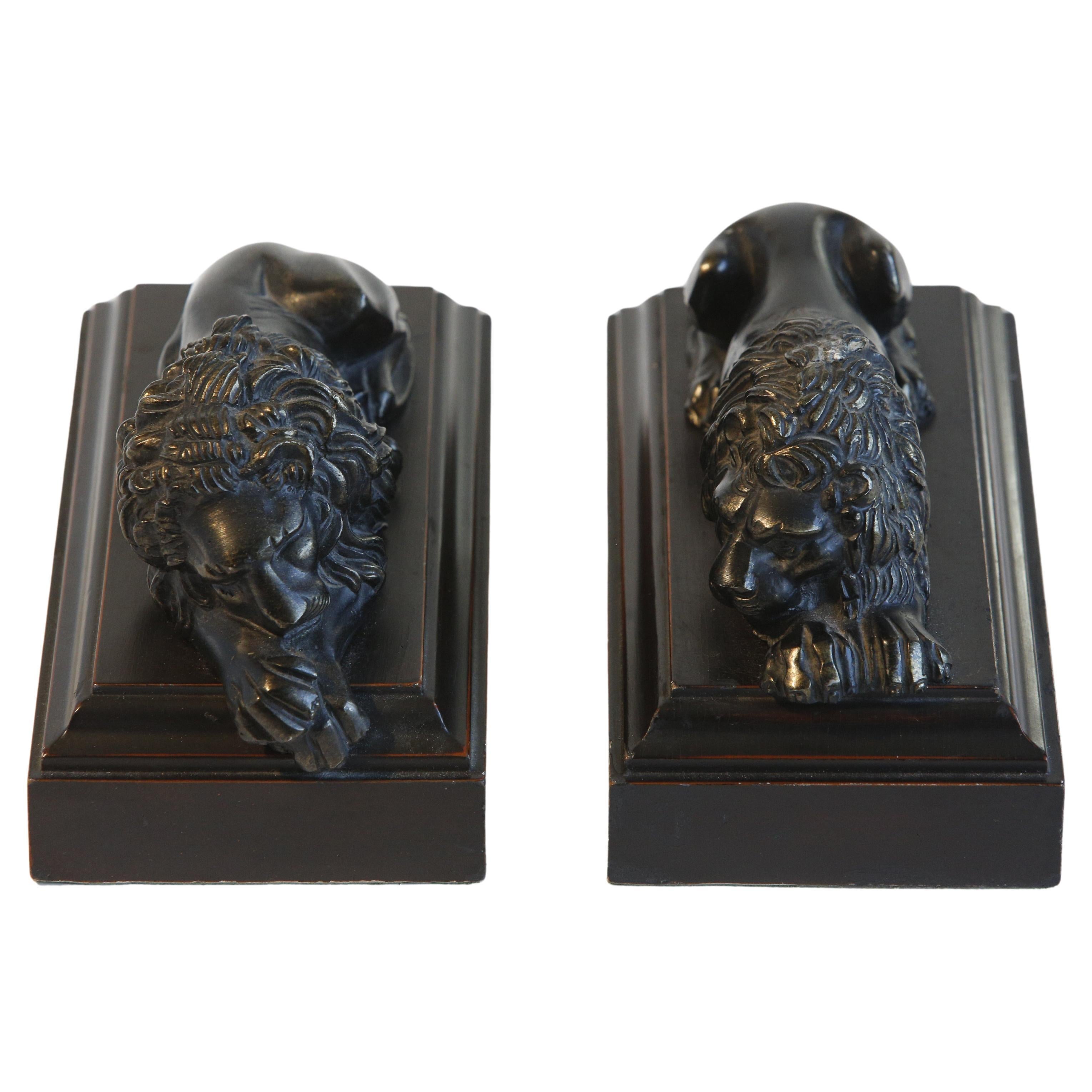 A pair of resting bronze lions on shaped walnut painted plinths modeled on the original marble sculpture by Antonio Canova.
        
Reduction from the originals created by Antonio Canova for the tomb of Pope Clement XIII in St. Peter's Basilica in