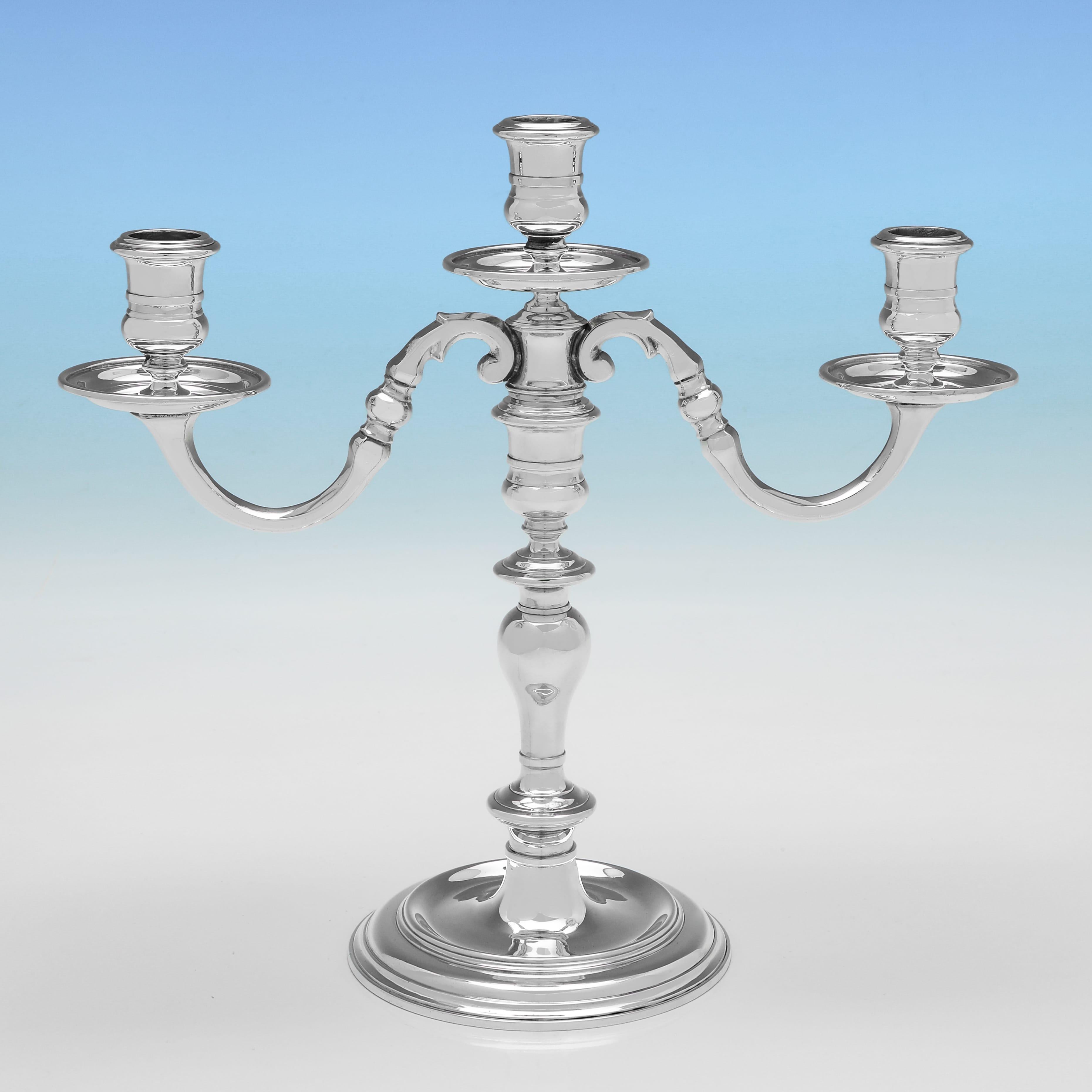 Marchiata a Londra nel 1977 da Wakely & Wheeler, questa bella coppia di candelabri in argento Sterling del periodo di Elisabetta II ha una forma rotonda, uno stile semplice e può contenere 3 candele ciascuno. Ogni candelabro misura 10,25