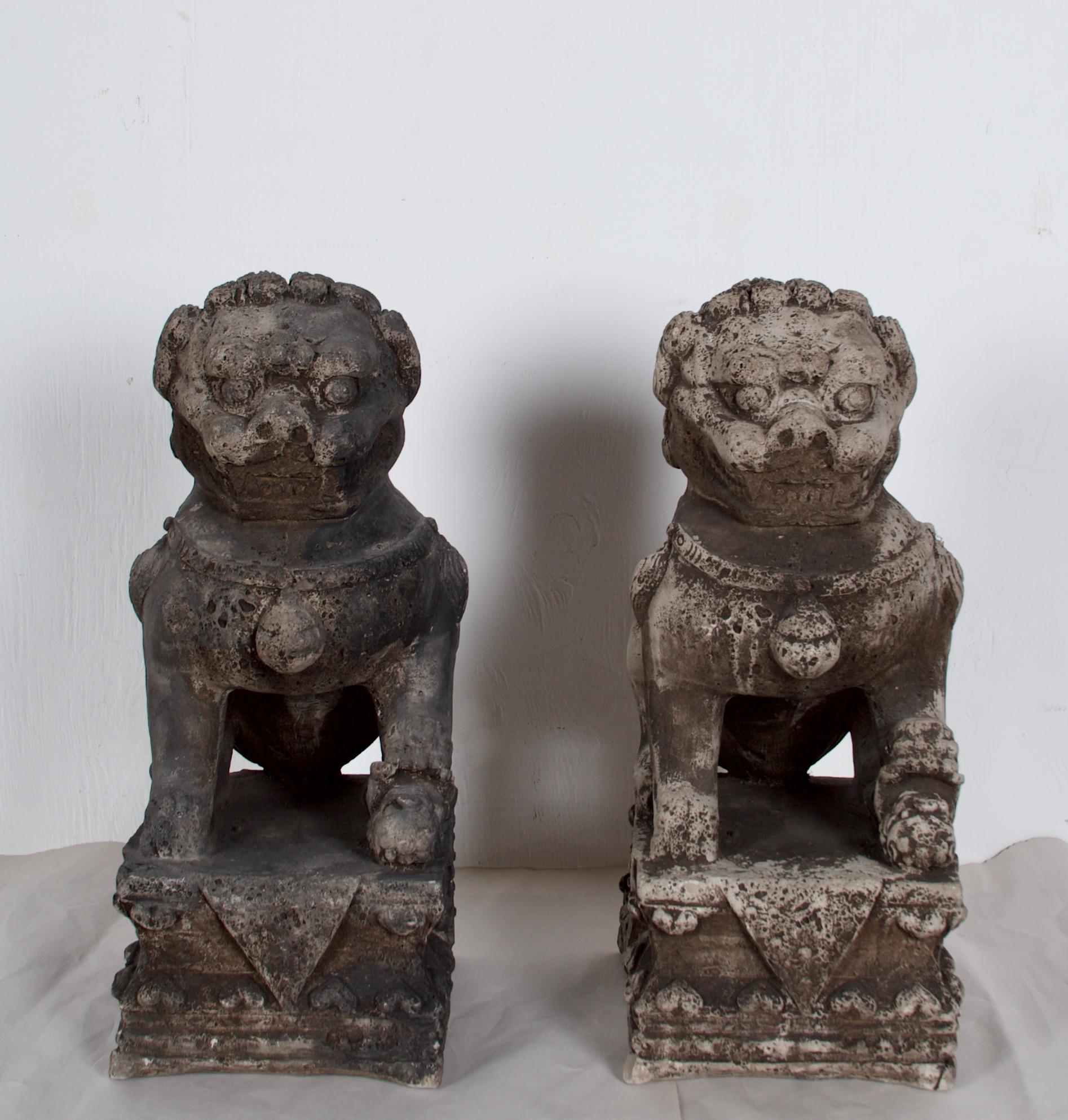 Playful pair of cast stone fire dogs, Foo Dog style. Great for use in a fireplace -
the pair is identical.