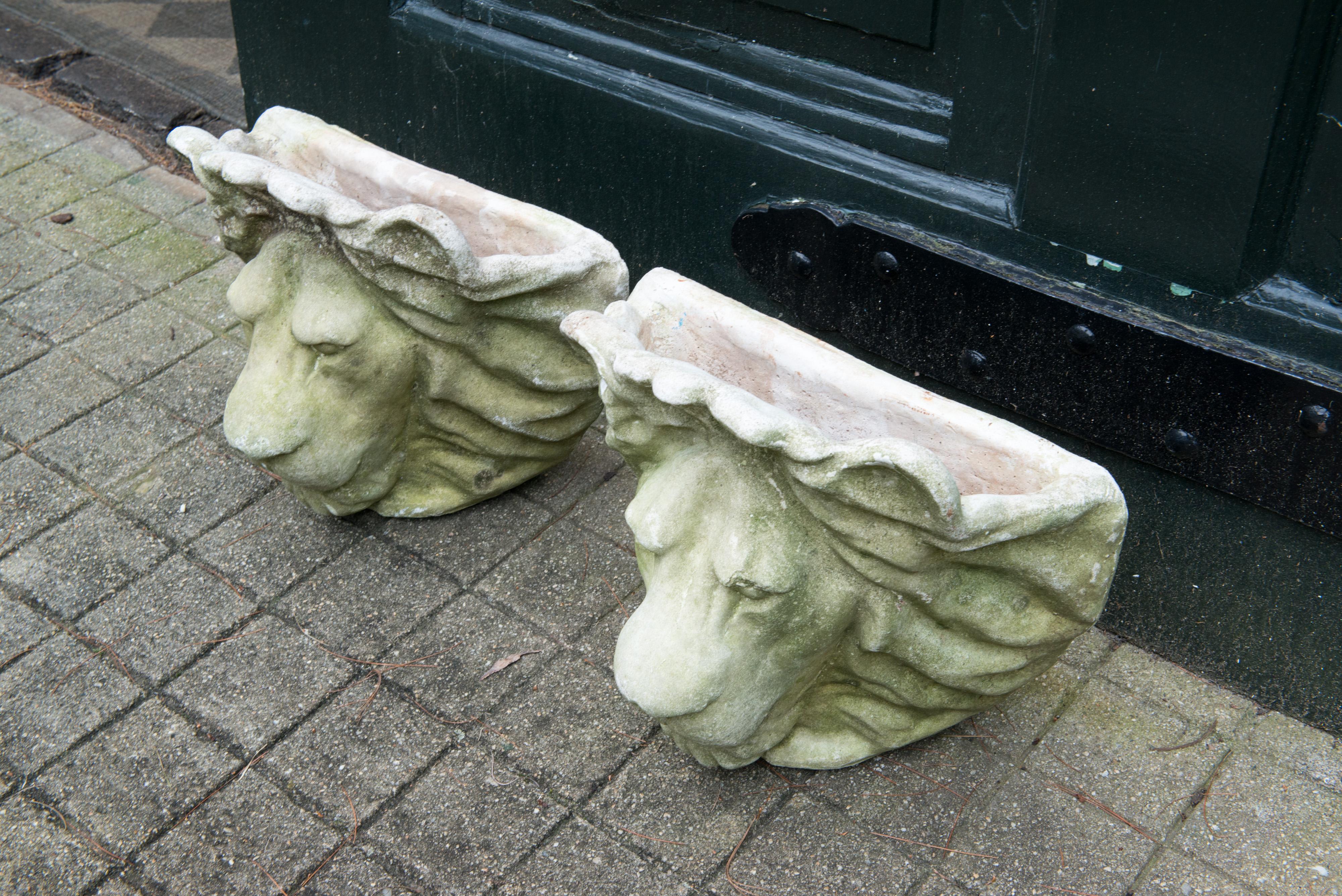 Pair of cast stone lion head wall planters.