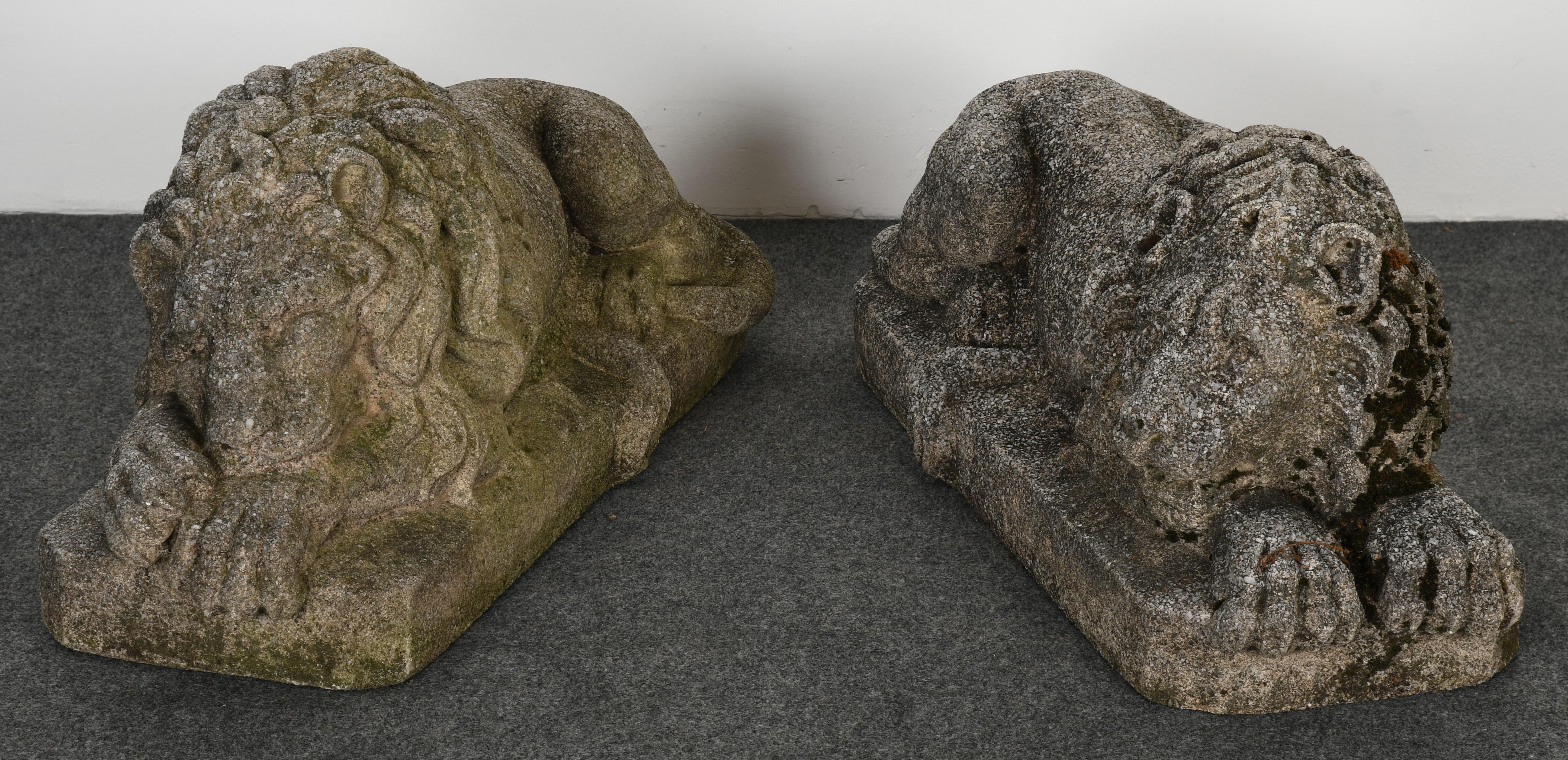 A stately pair of cast stone recumbent lions. These lions have a lot of personality and each one is slightly different. The pair of lions were displayed on an estate at the foot of a pair of outdoor stairs. Great color and patina. 

Dimensions: