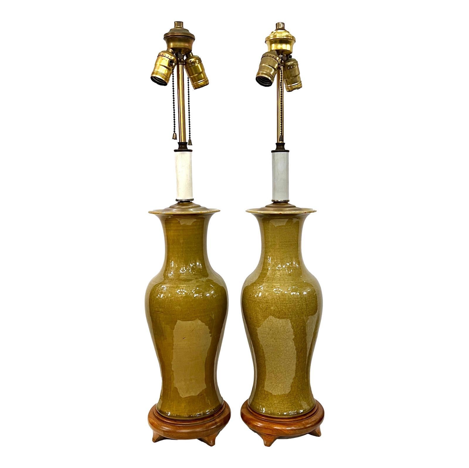 Pair of circa 1940s French celadon tone porcelain lamps with crackled finish and wood bases.

Measurements
Height of Body: 18