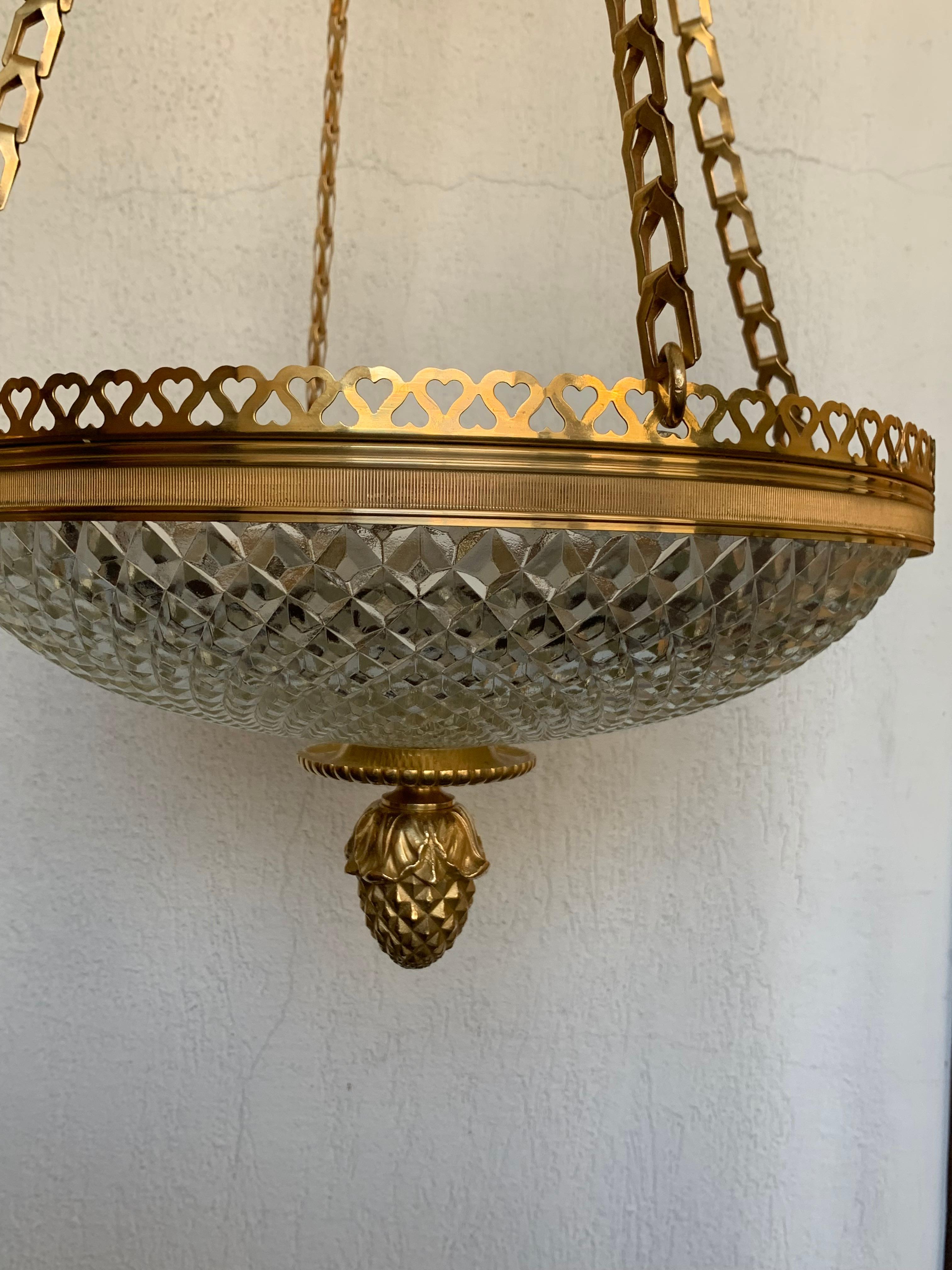 A high end decoration pair of chandelier louis XVI style in baccarat cut crystal and gilded bronze
the central crystal cup is embedded by an openwork bronze belt and ends with a finely chiseled bronze seed ,it is supported by 4 bronze chains which