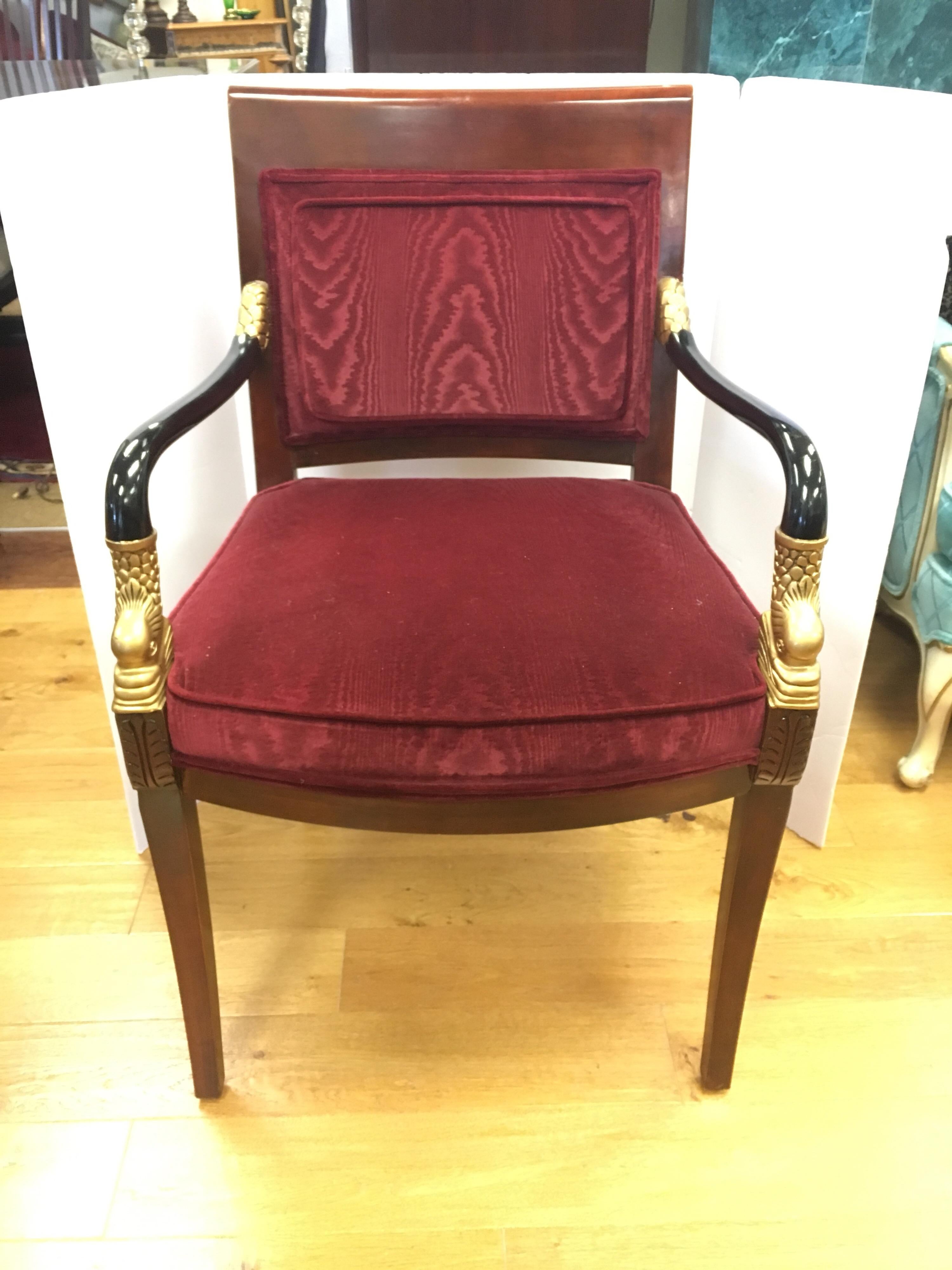 Elegant century furniture Biedermeier armchair upholstered in a burgundy velvet. Features two-tone colored wood (brown and black) with carved gold dolphin heads.