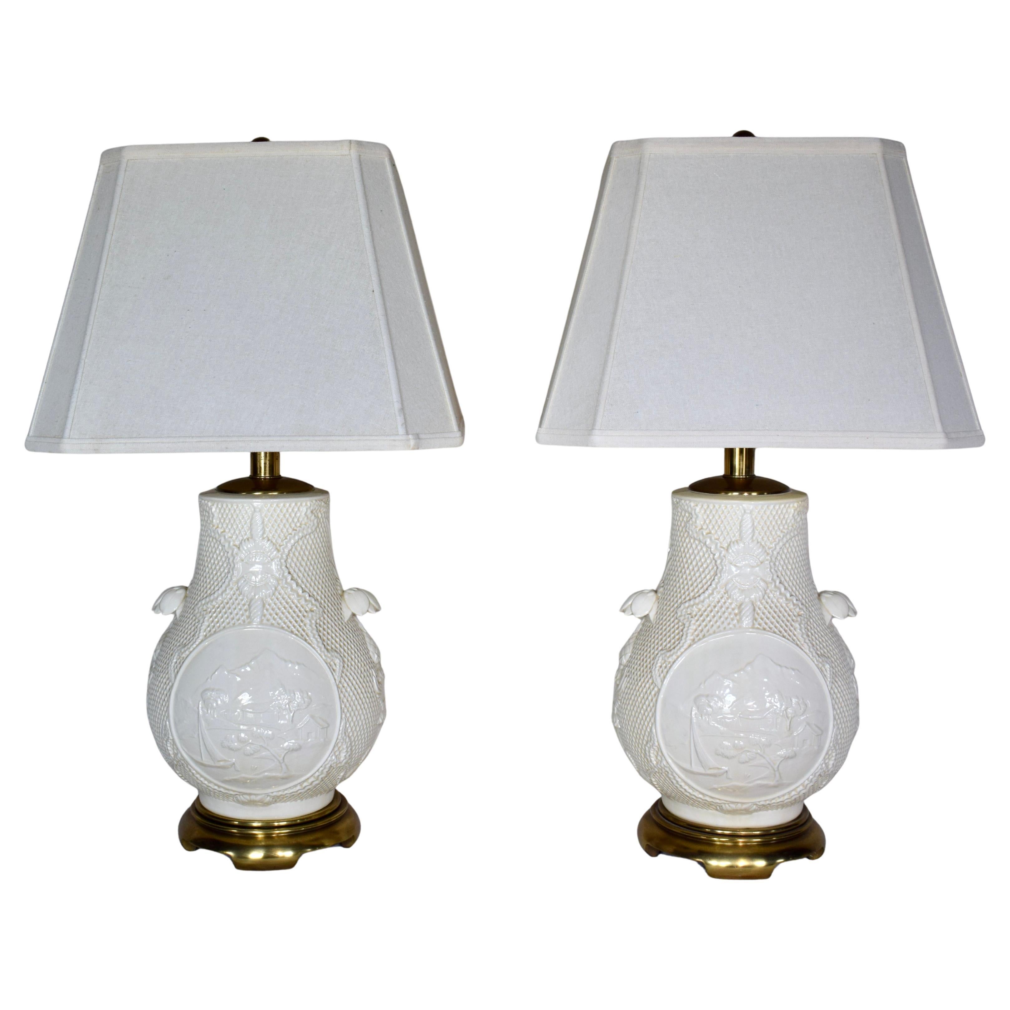 A pair of Blanc de Chine Chinoiserie lamps by Paul Hanson Lighting Company; 1960's. Exquisite details include  decorative basket weave ground with mountain lake scenes, petaled Lotus flower embellishments on heavy brass bases. Additional dimensions: