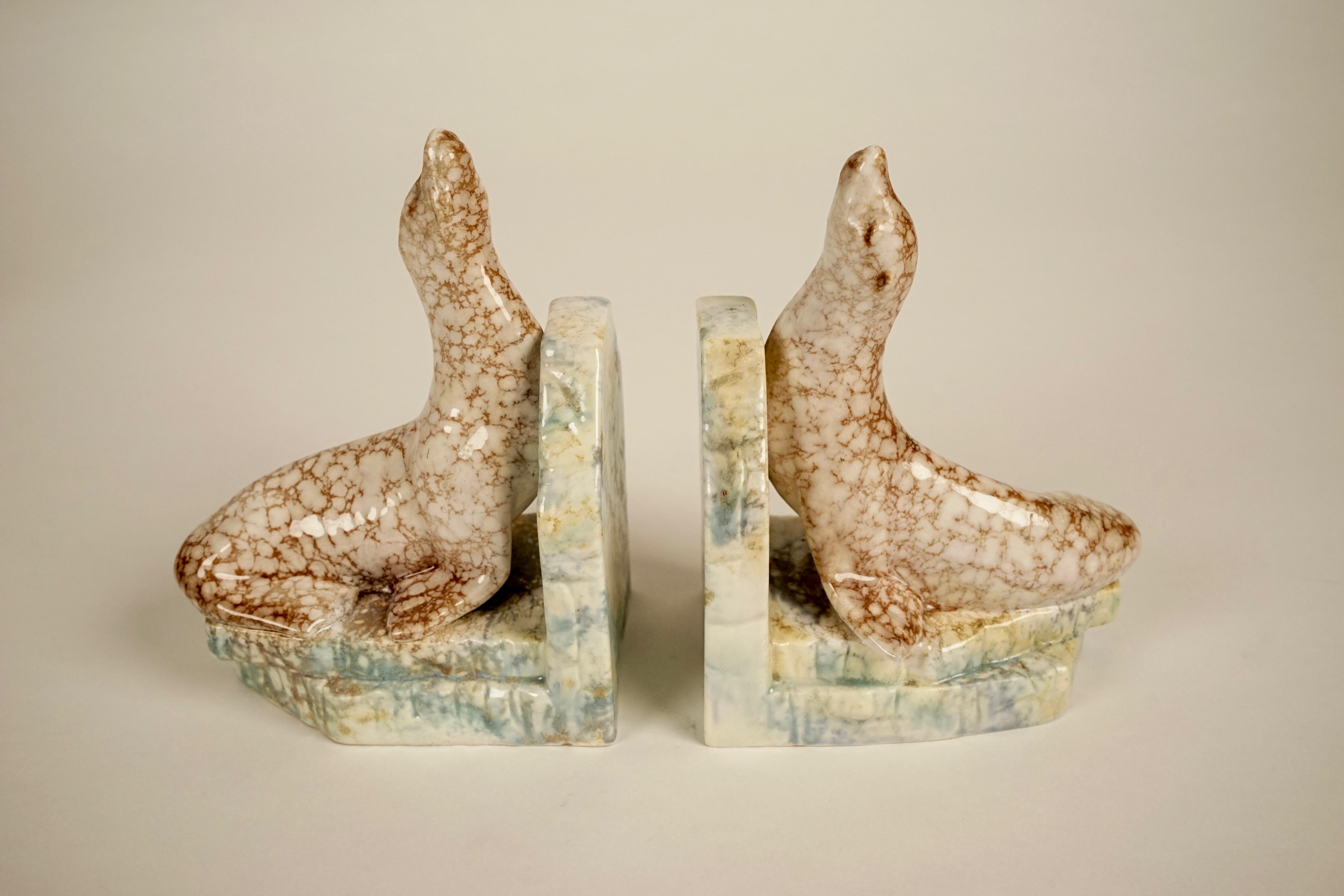 Pair of ceramic bookends from 1930s, produced in Czechoslovakia.
Bases are glazed in light green and yellow, the seals in brown and off white.