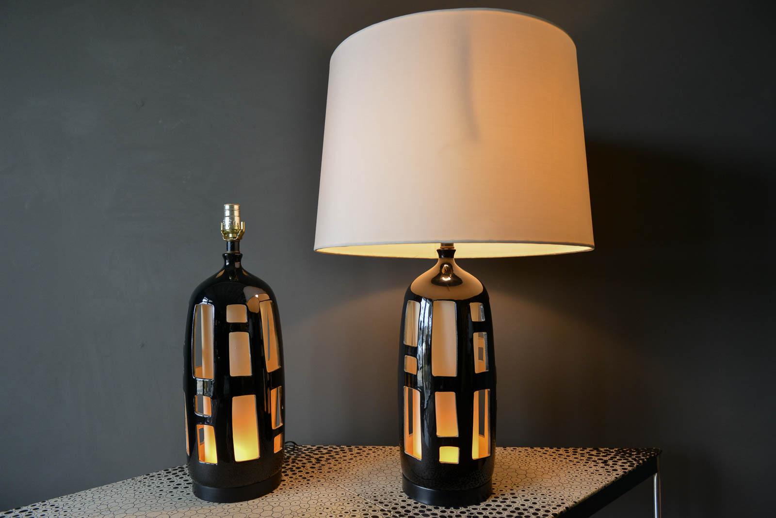 Pair of ceramic cutout lamps with dual illumination, circa 1970. Beautiful black and white design with independently controlled top and bottom switch to illuminate the column or neck separately. Excellent original condition. New wiring.

Measure: