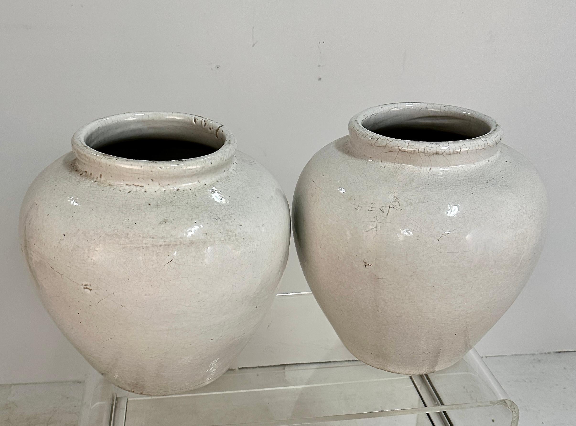 A great pair of heavy ceramic jars. Unfortunately unsigned but almost certainly American art pottery. Lovely glaze and thick-walled construction make them perfect for indoor or outdoor use in temperate zones. The size is useful at 16