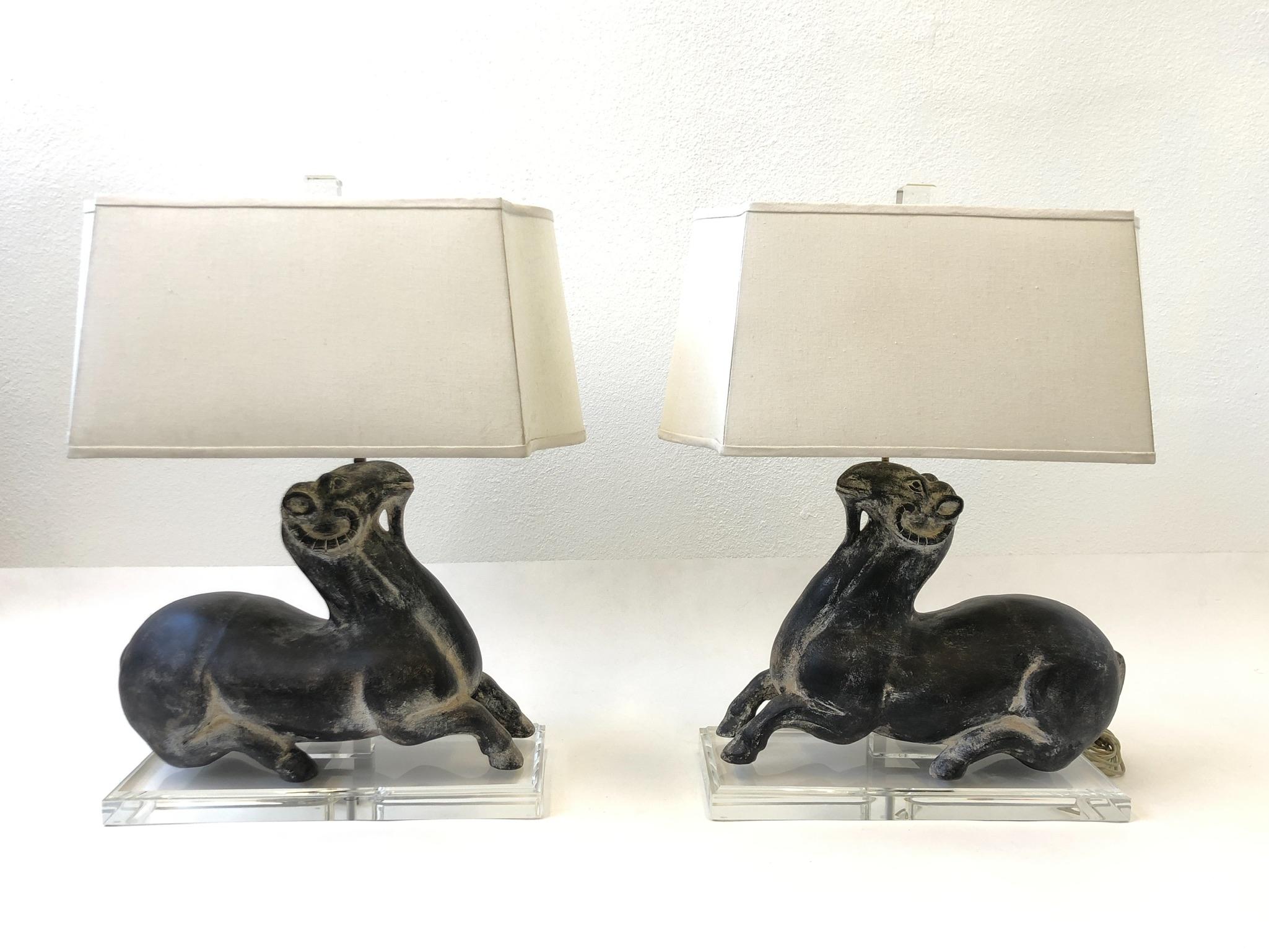 A beautiful pair of hand painted ceramic goats on a Lucite base, table lamps designed by Steve Chase in the 1980s. This were specially designed for a interior design project by Steve Chase. The lamps are in original condition, so they show minor