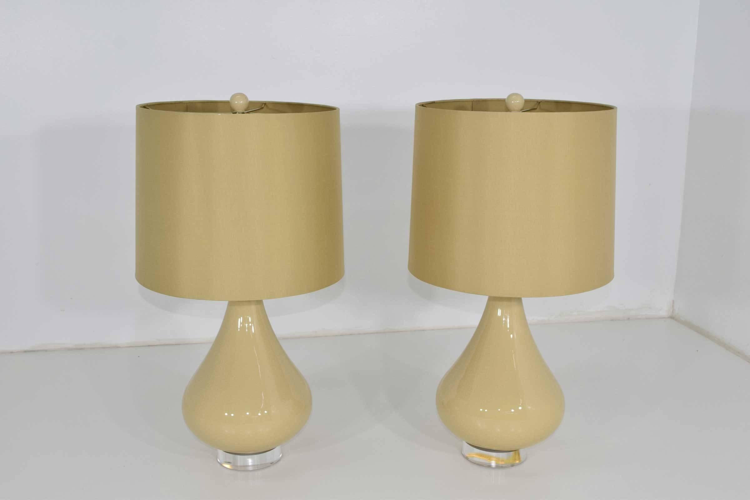 A very nice pair of ceramic lamps with Lucite bases, matching finial and silk shades.
