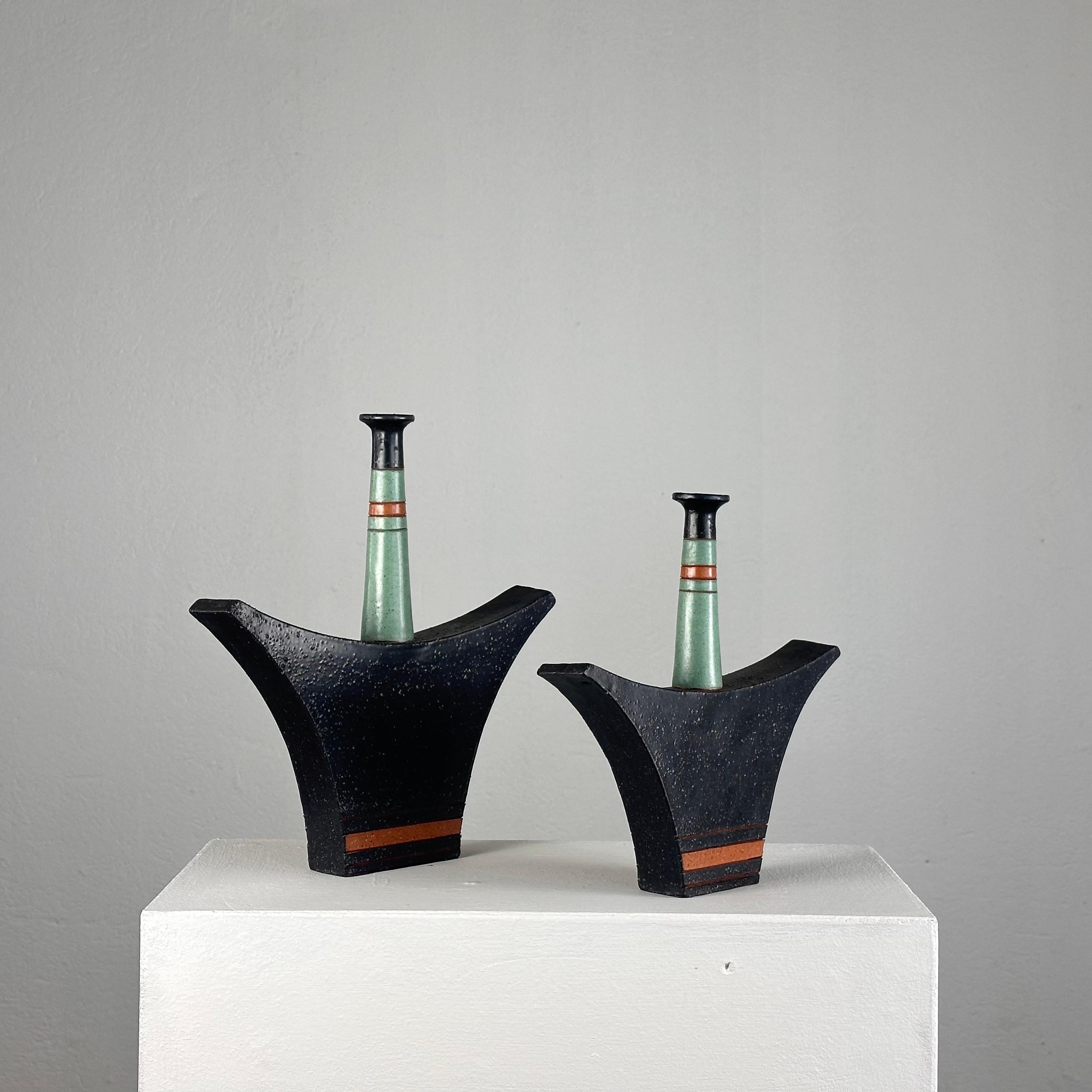 Illuminate your space with the vibrant spirit of the 1980s with this captivating pair of ceramic vases by the renowned Italian artist Vanni Donzelli. Crafted during the heyday of Memphis design, these vases epitomize the era's bold colors, geometric