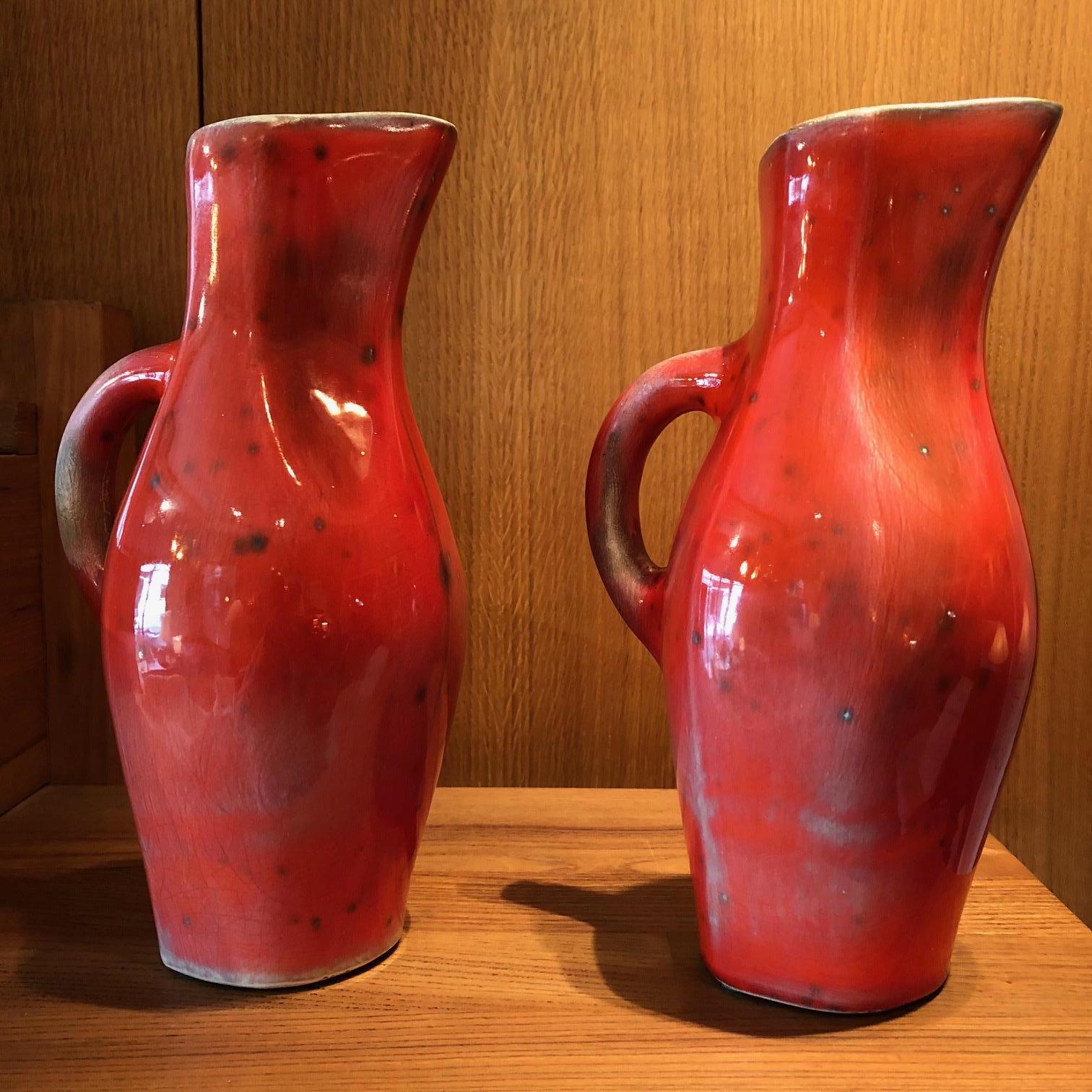 Pair of red-glazed ceramic pitchers by Georges Jouve, 1950s