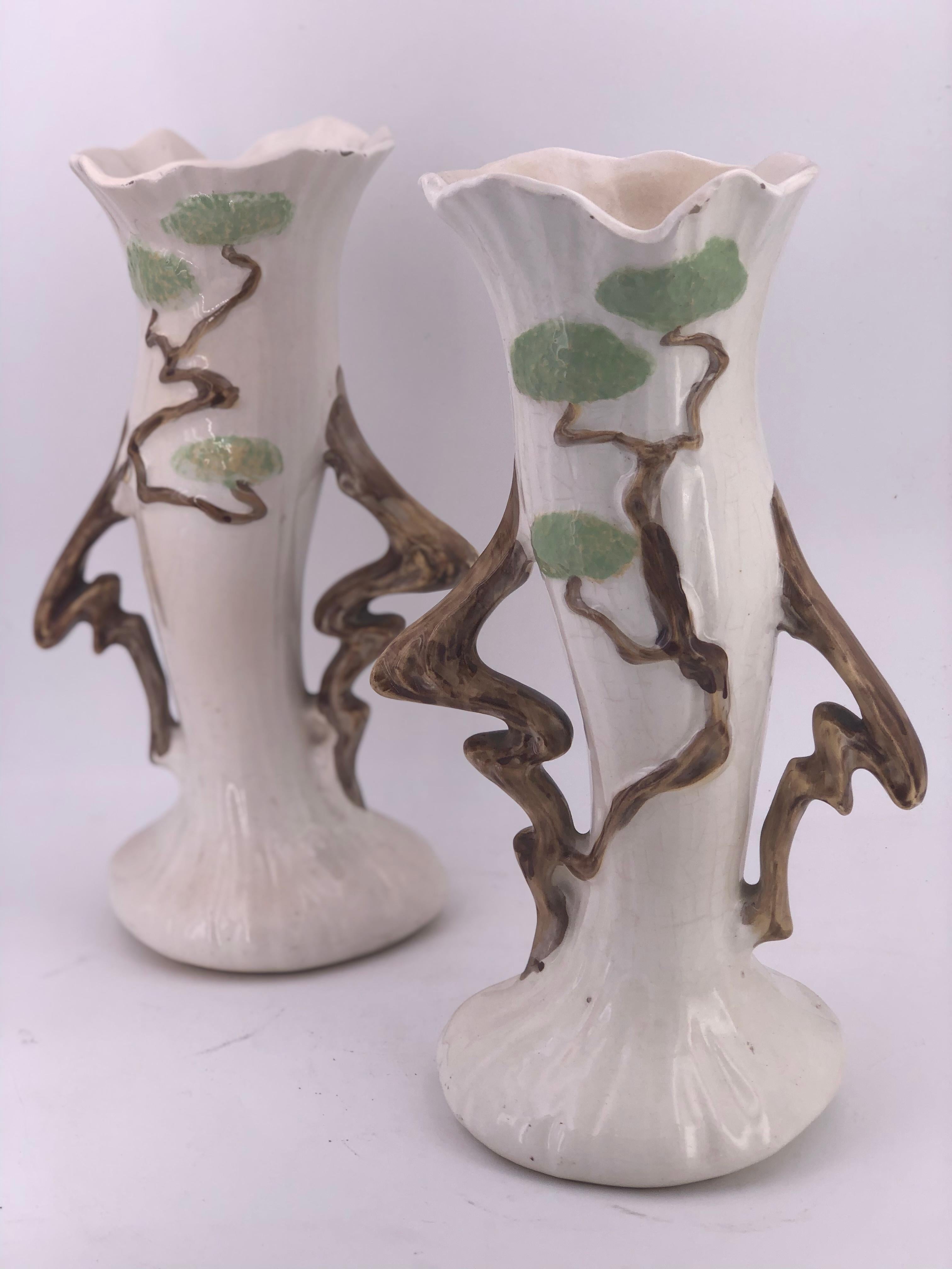 A beautiful pair of ceramic vases by Roseville pottery. This pair shows natural wear and a couple of flea bites on the edge. The overall condition is good.