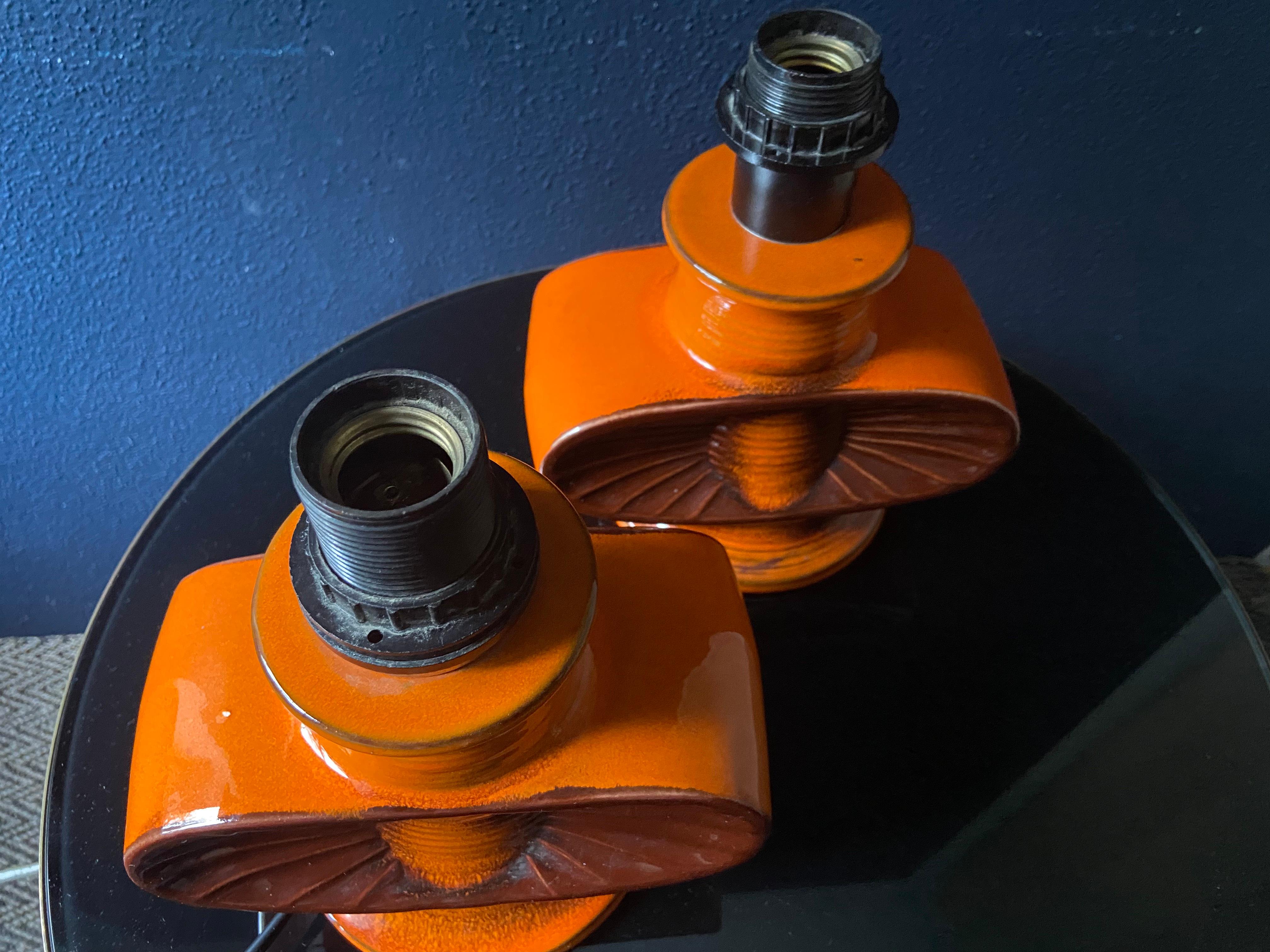 Questa coppia di lampade in ceramica arancione e marrone nello stile West German Pottery / Fat Lava è in  condizioni eccellenti, senza crepe o scheggiature. 

Pensiamo che siano della manifattura tedesca Goebel Porzellan, nota soprattutto per le sue