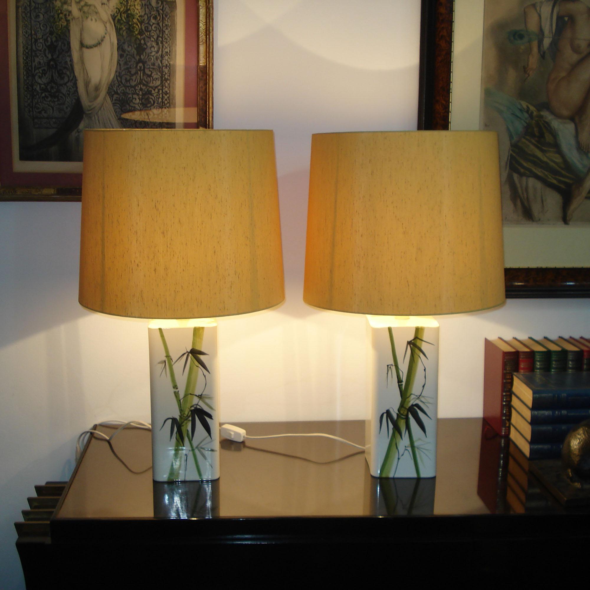 An exceptional, highly decorative pair of table lamps, produced in the 1960s under the famous Swedish brand NK (Nordiska Kompaniet). Glazed porcelain, hand painted with bamboo decor, each equipped with an E27 socket that fit with the US. Each lamp