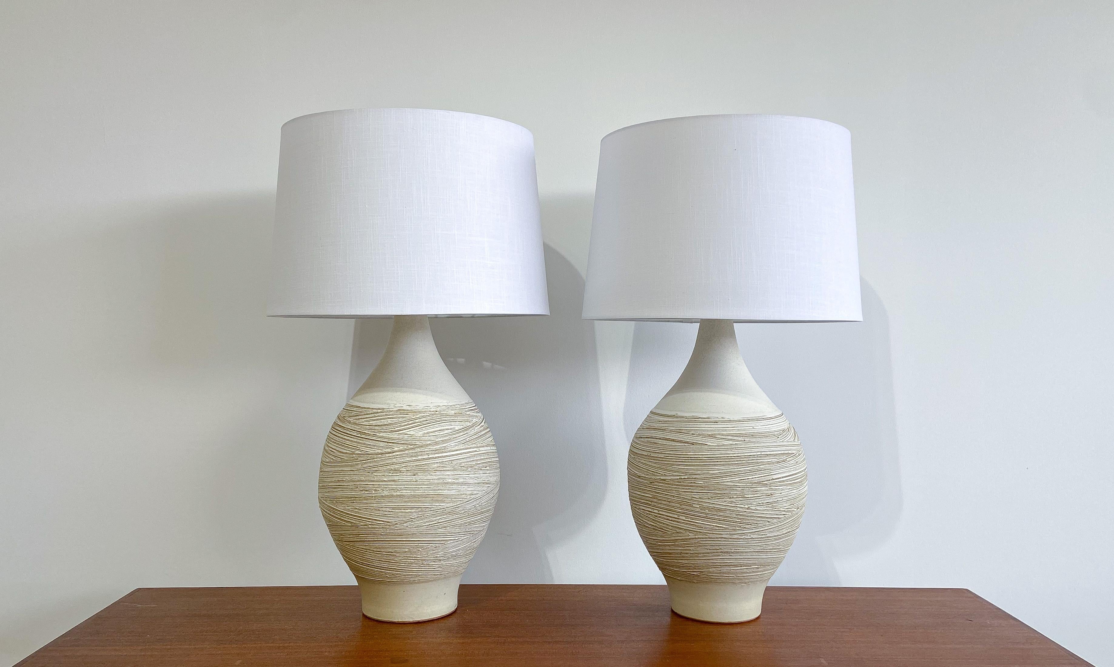 Offered is an impressive pair of ceramic table lamps designed by Lee Rosen for Design Technics.

Each featuring a Classic bottle form, with a unique hand-incised pattern for a wonderful overall aesthetic and texture. 

Both lamps appropriately
