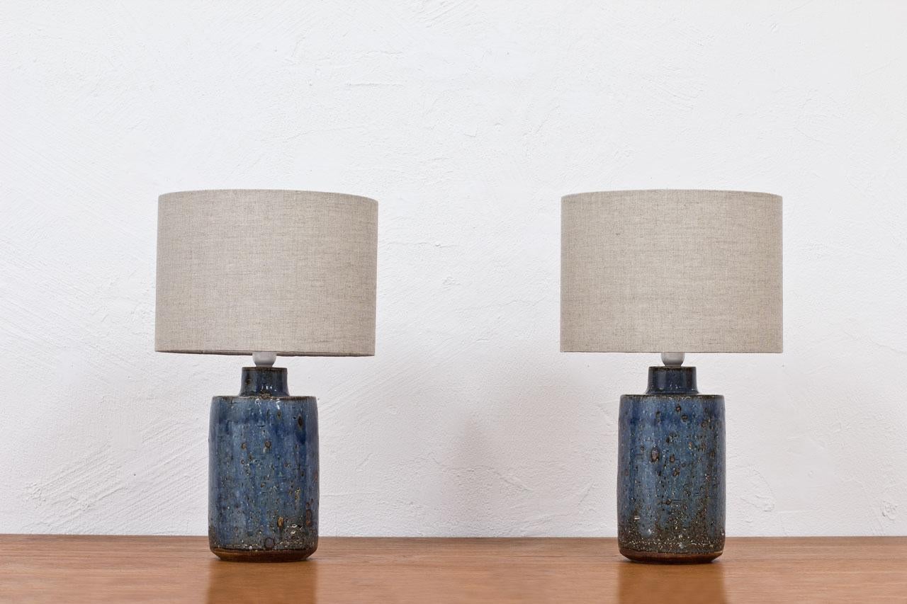 Stoneware table lamps designed by Marianne Westman. 
Hand made at Rörstrand studio in Sweden during the 1960s.
Rustic glaze in blue and green. 
New linen lamp shades in beige (natural) color. 
The wiring has been redone with original light